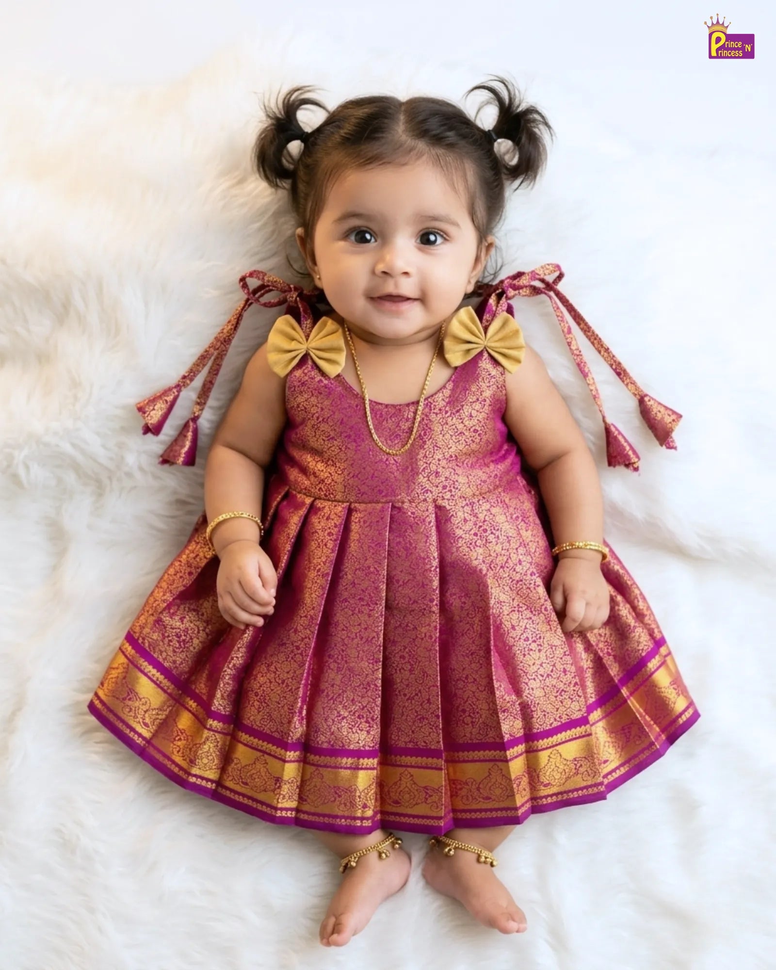 Child wearing a pink and gold traditional outfit on a white background