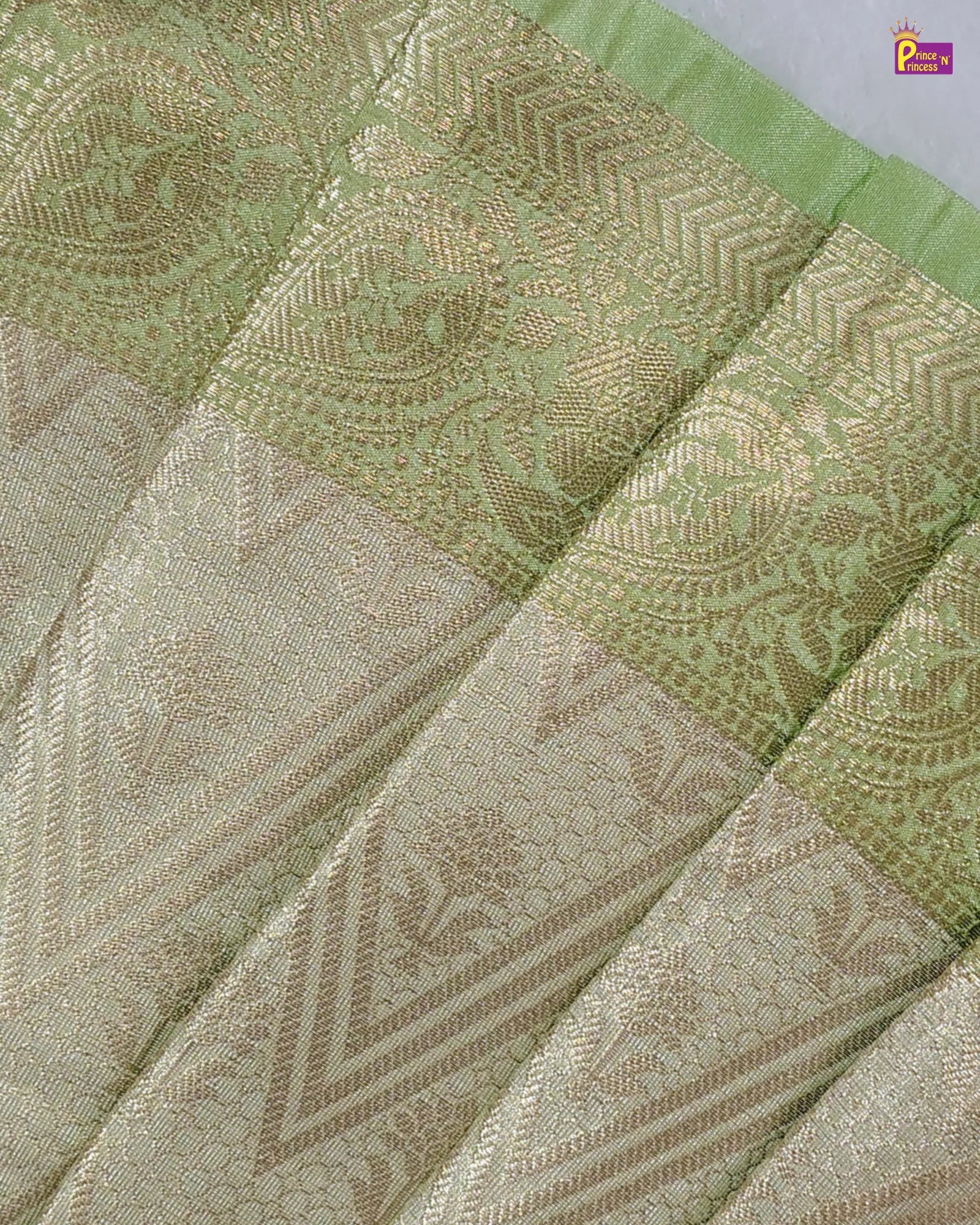 Close-up of a green and beige patterned fabric with intricate designs.