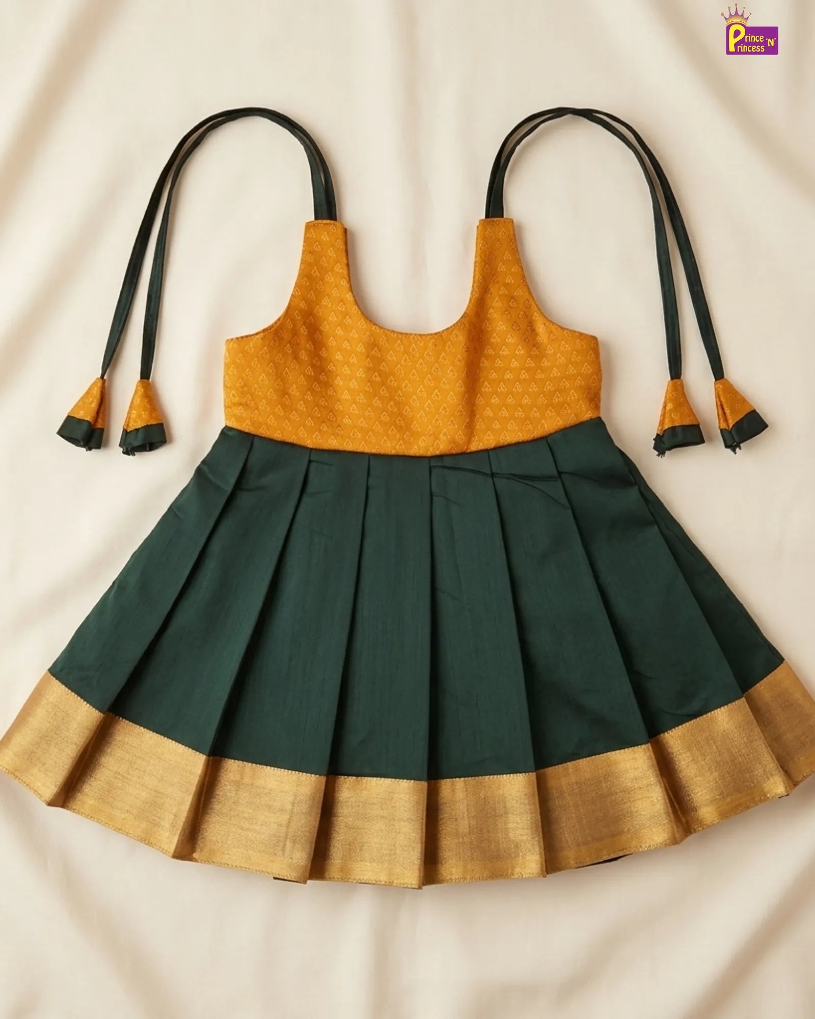Children's dress with mustard top and green skirt on a beige background