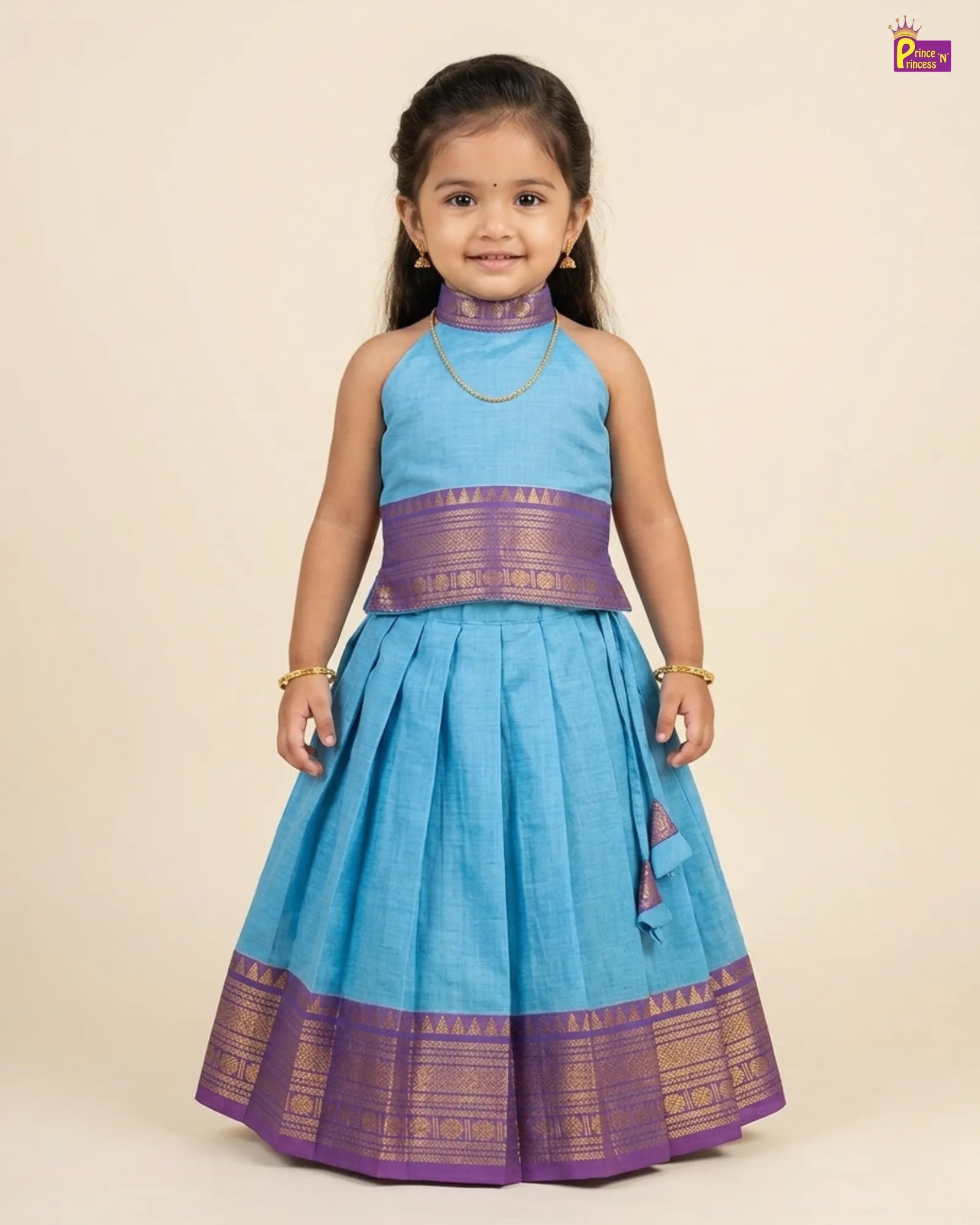 Young girl wearing a blue and purple traditional outfit on a beige background