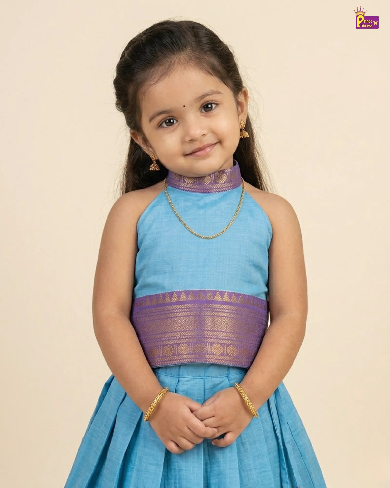 Young girl wearing a blue and purple traditional outfit against a beige background