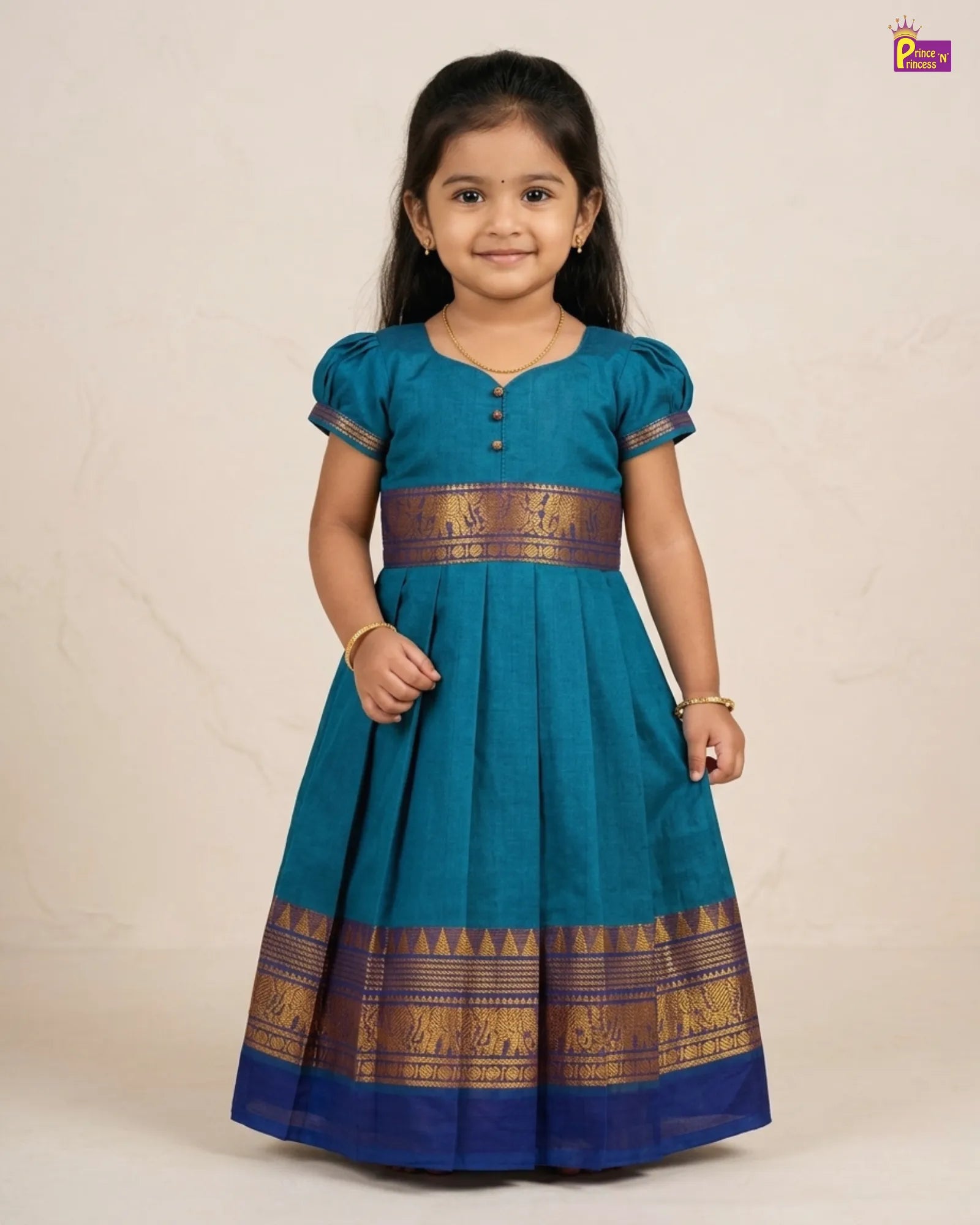 Young girl wearing a teal dress with gold patterns on a beige background
