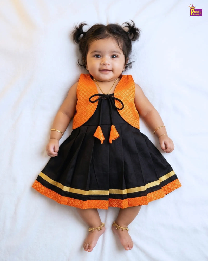 Baby wearing a black and orange dress on a white background