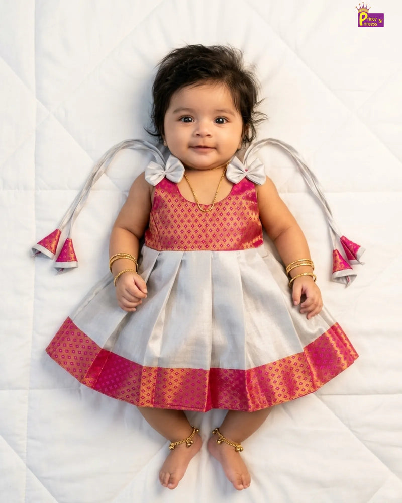Baby wearing a traditional outfit with pink and white colors on a white background