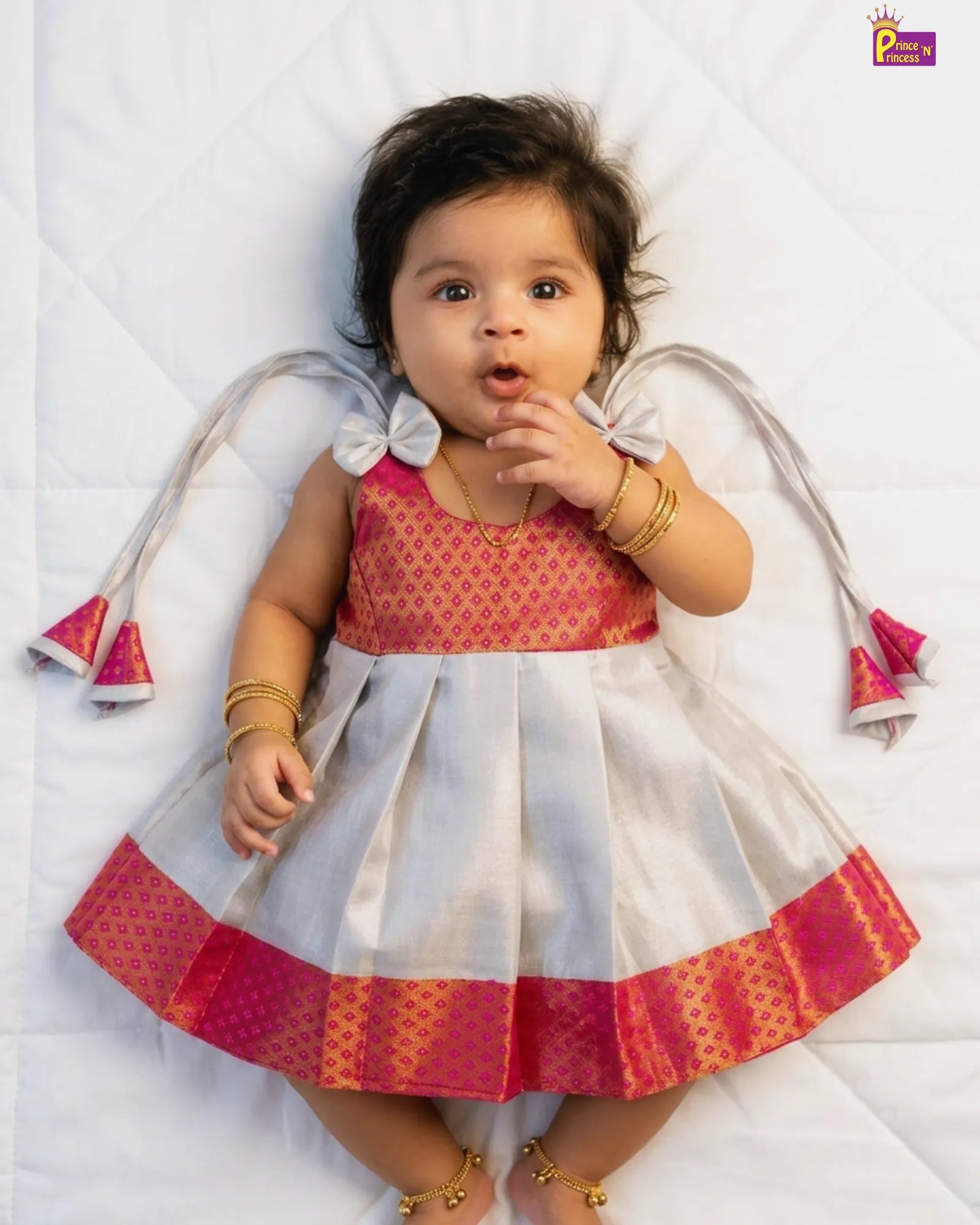 Baby wearing a traditional outfit with red and white colors on a white background