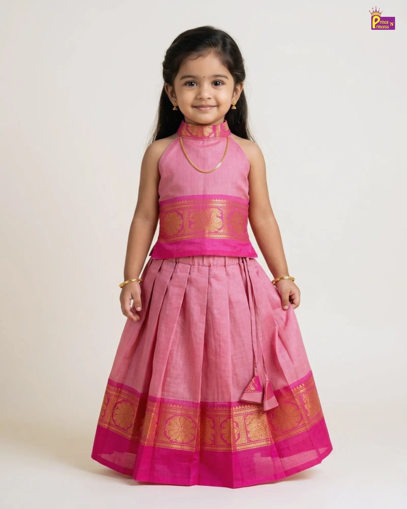 Baby in traditional outfit with gold and maroon colors on a white background