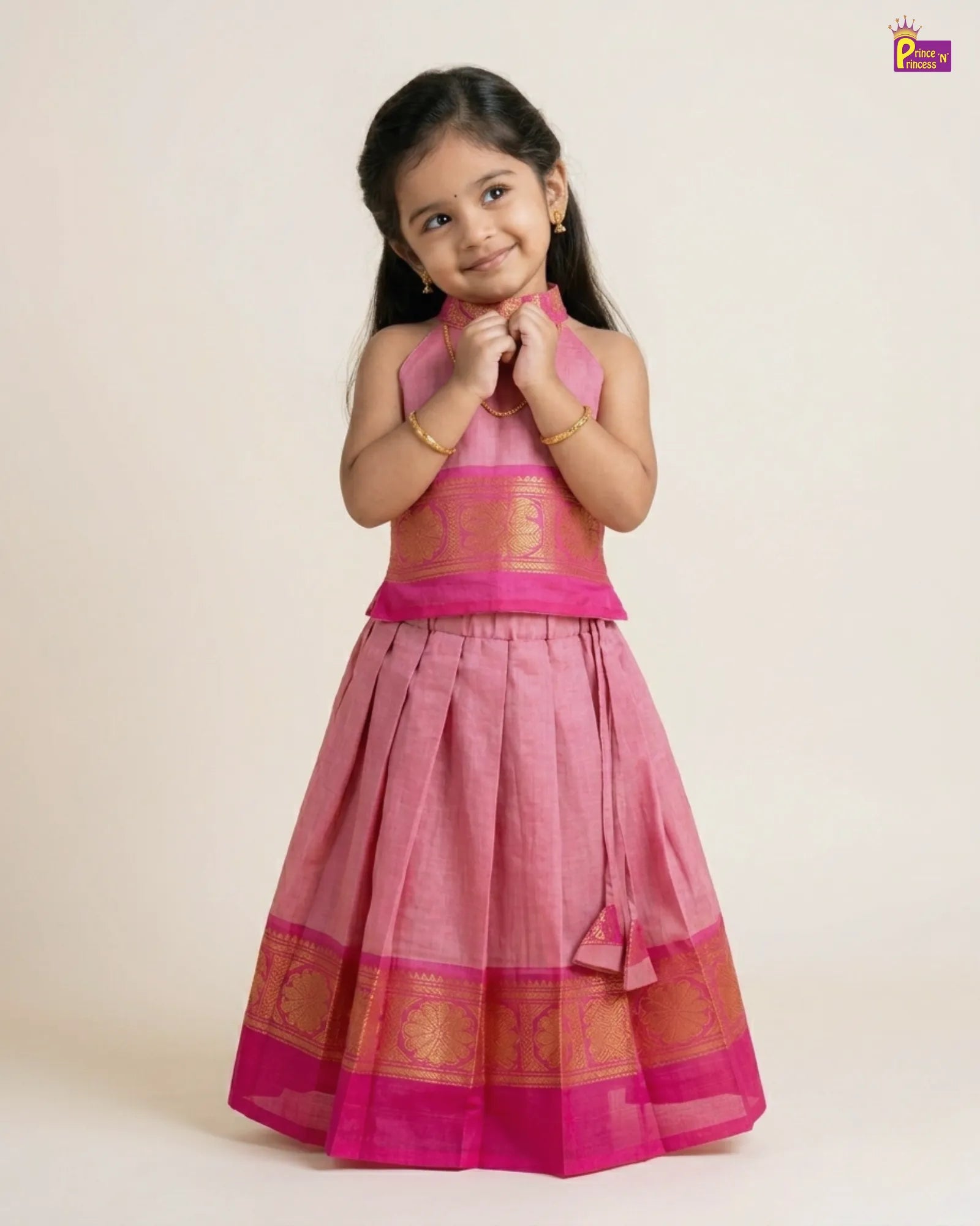 Young girl wearing a pink traditional outfit with gold accents on a beige background