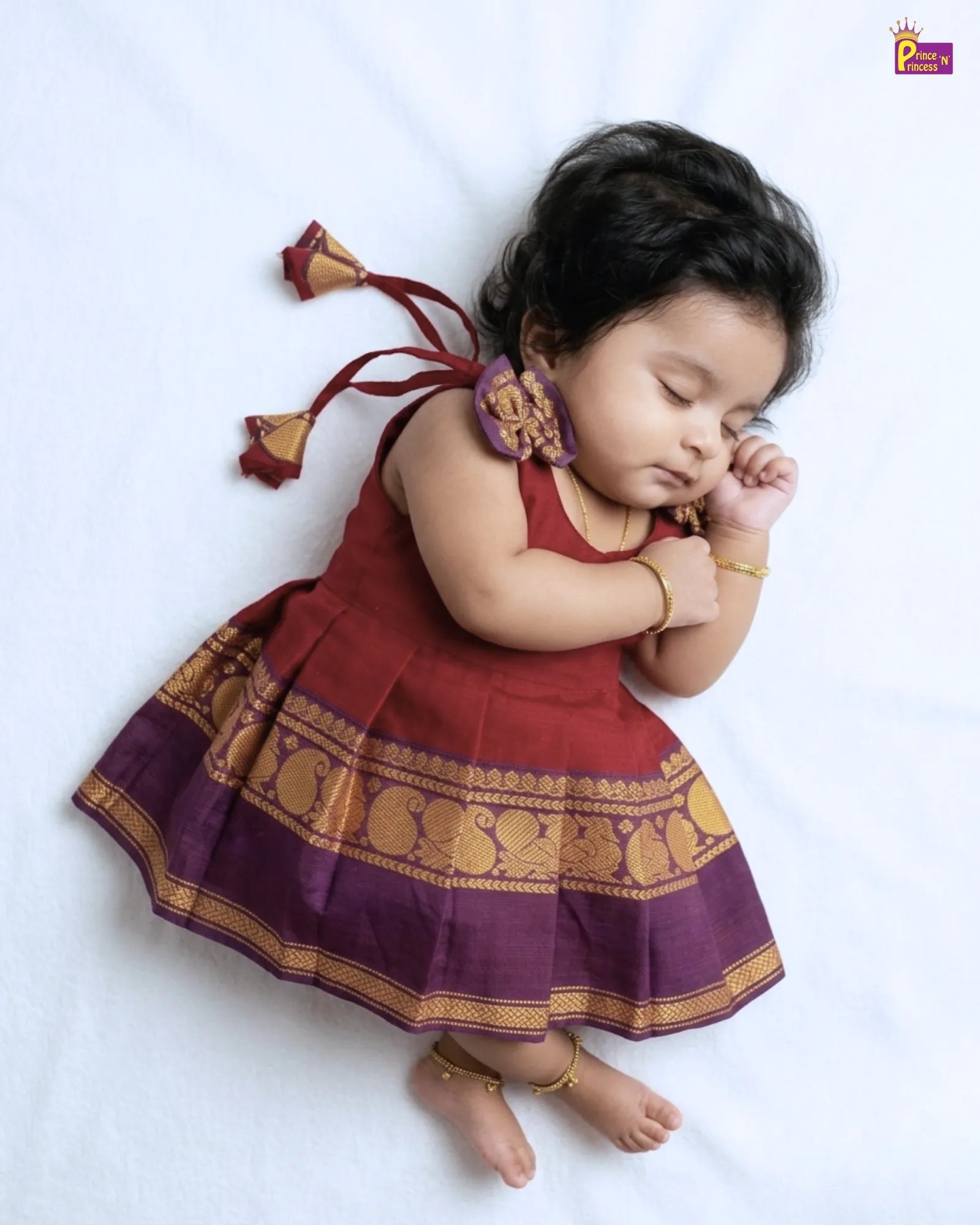 Baby in a traditional outfit with a white background