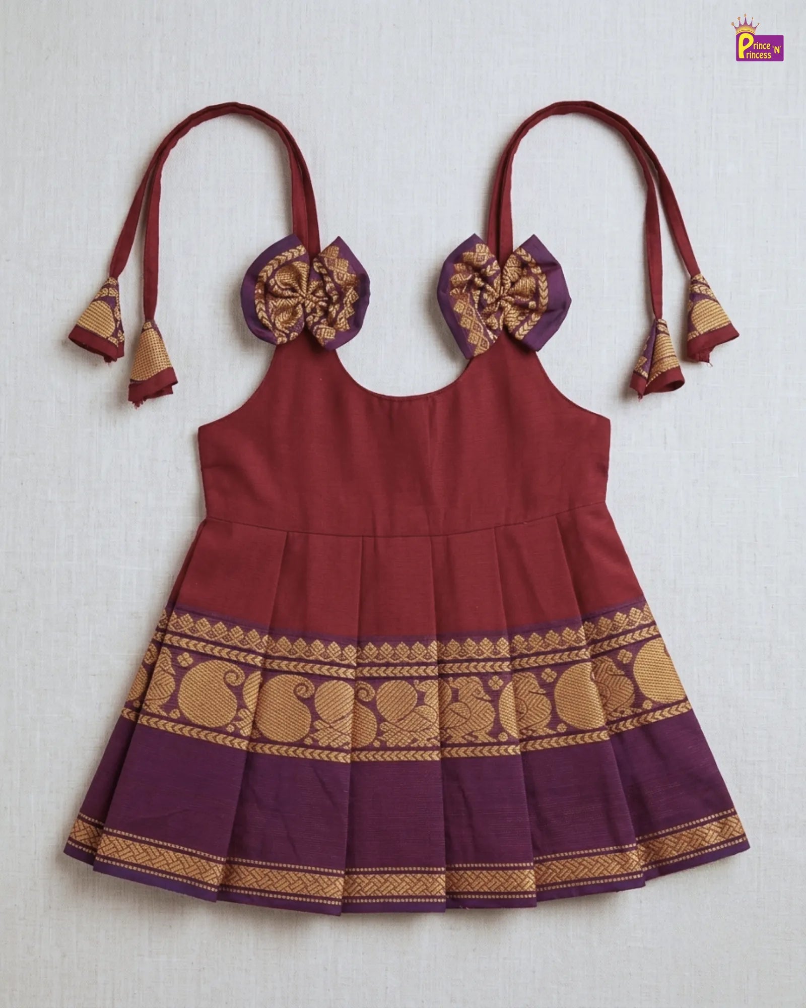 Maroon dress with gold and purple details on a white background