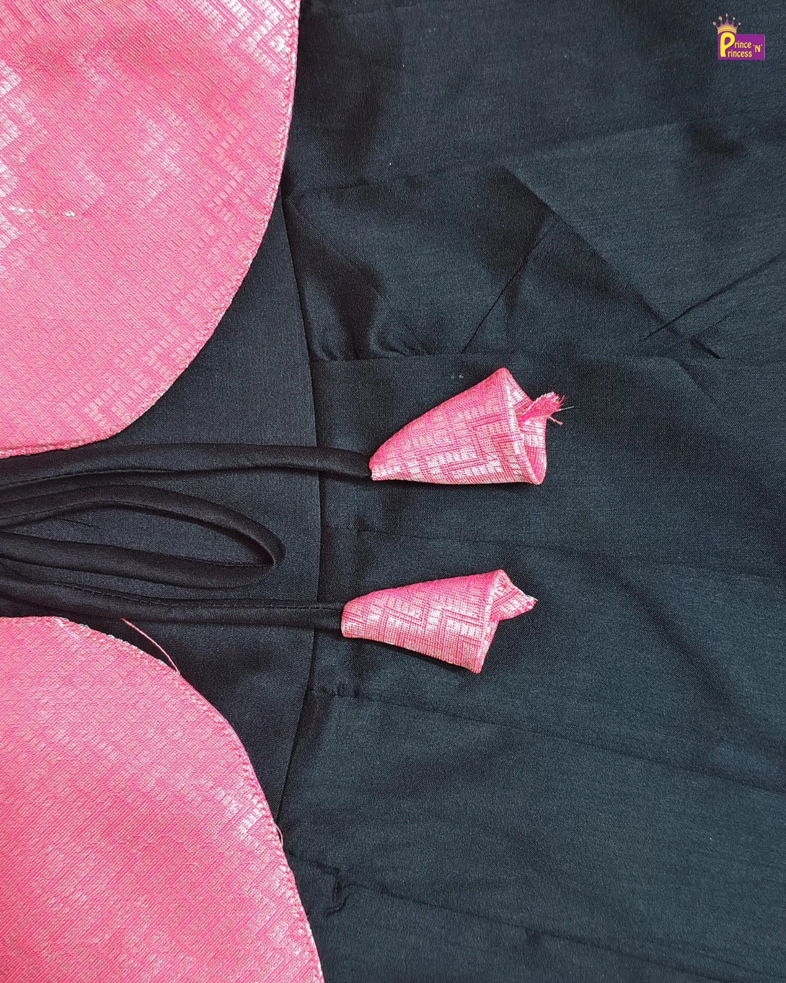 Black garment with pink floral patterns on a pink background