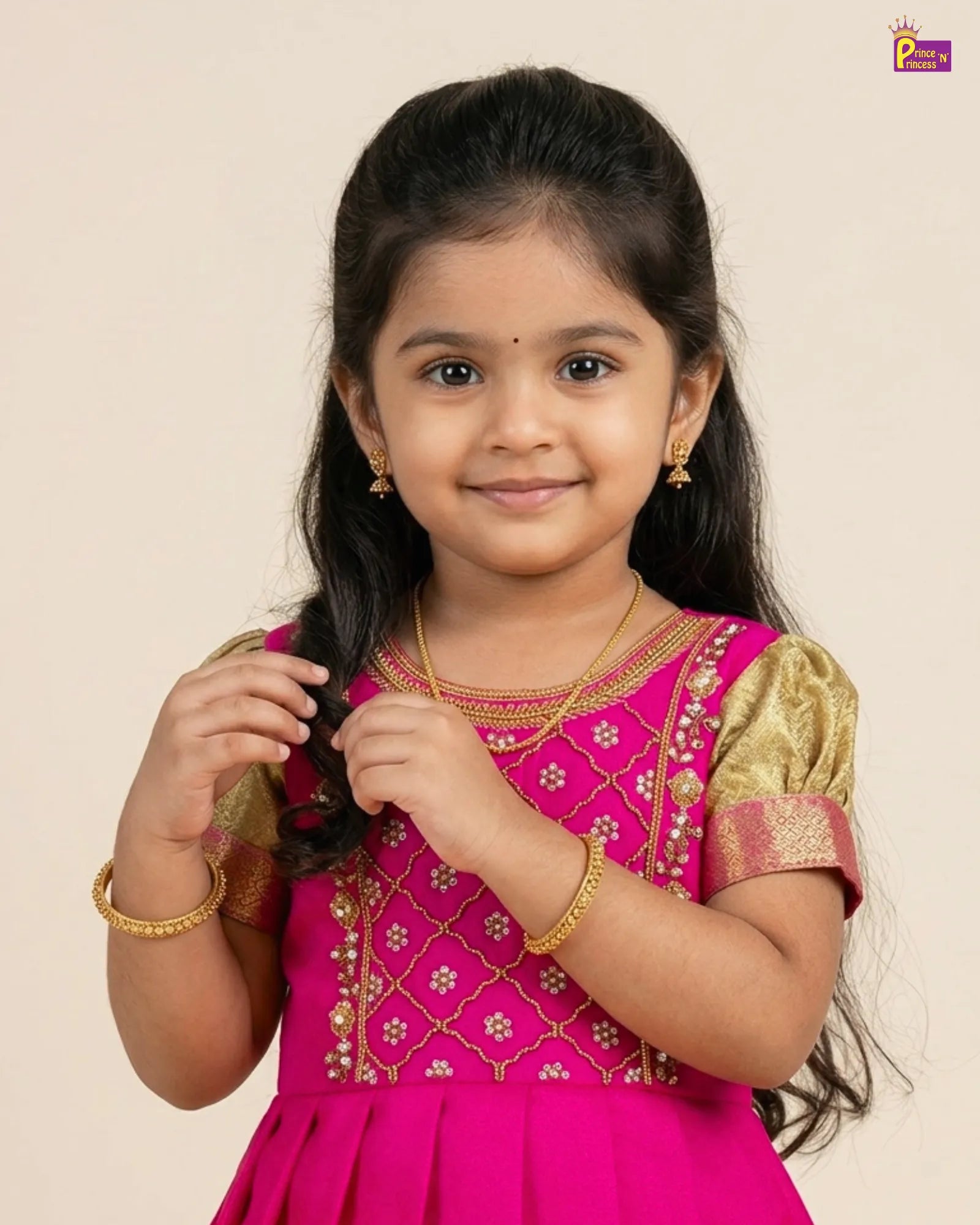 Young girl in a pink and gold traditional outfit with a plain background