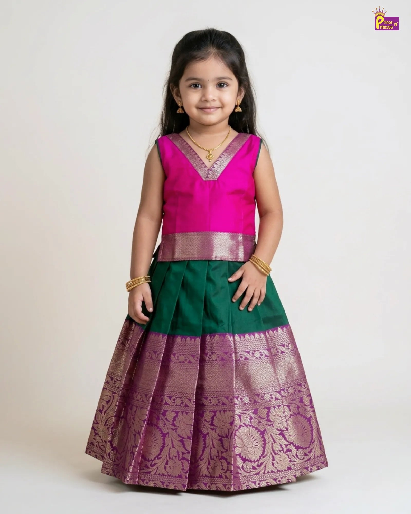 Young girl wearing a traditional outfit with a pink blouse and green and purple skirt on a white background