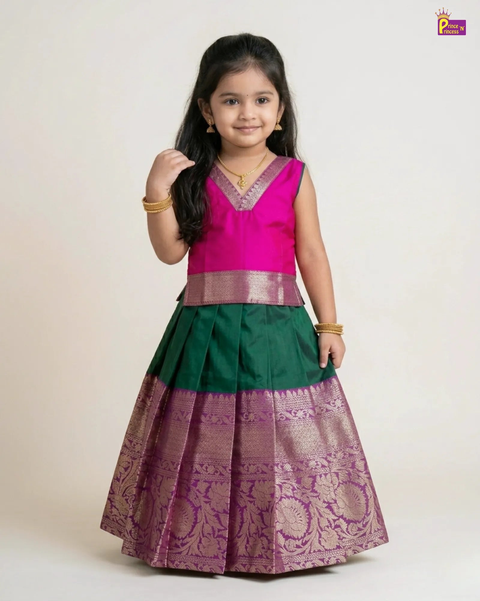 Young girl wearing a traditional outfit with a pink top and green and purple skirt on a white background