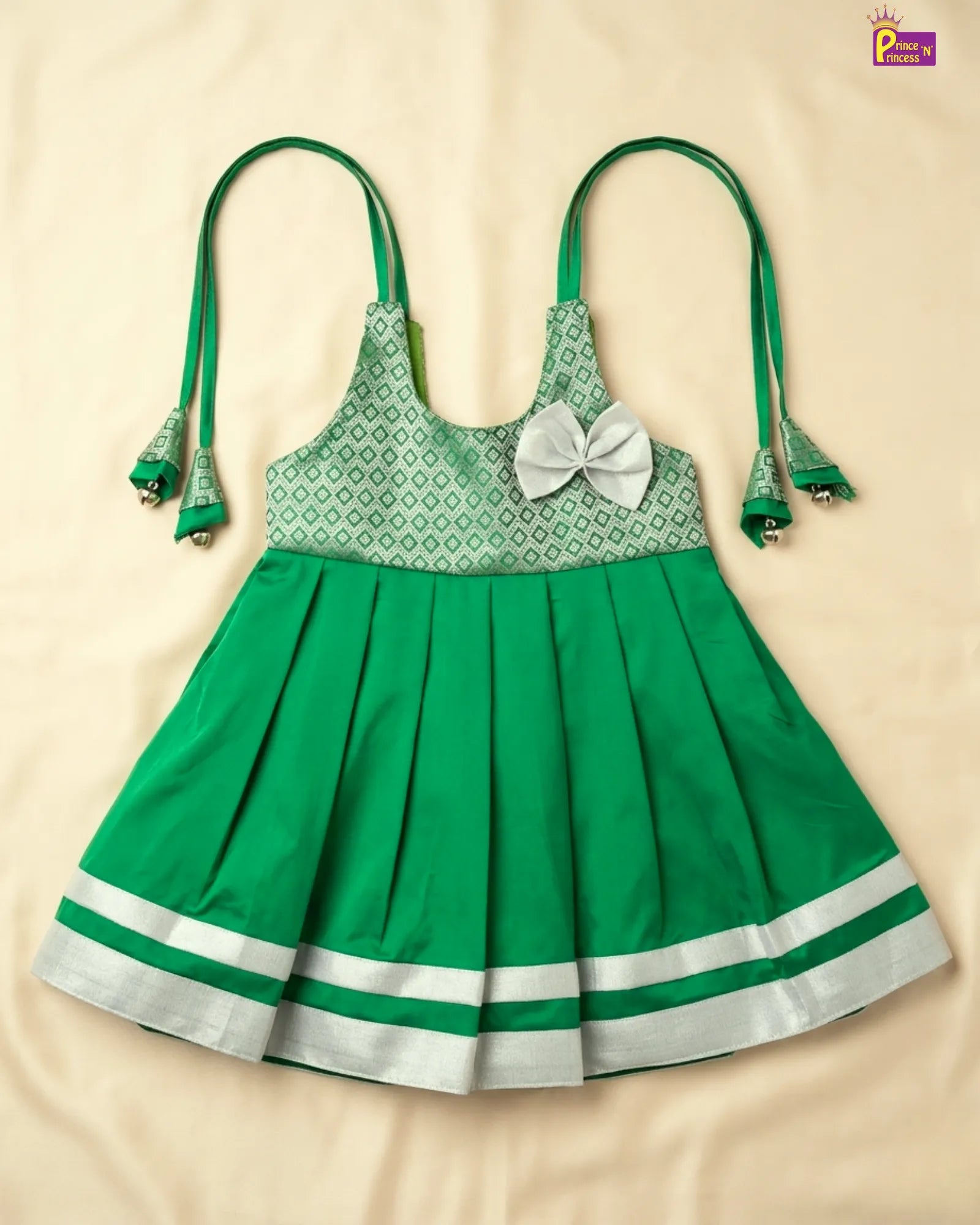 Green dress with white pattern and bow on a beige background