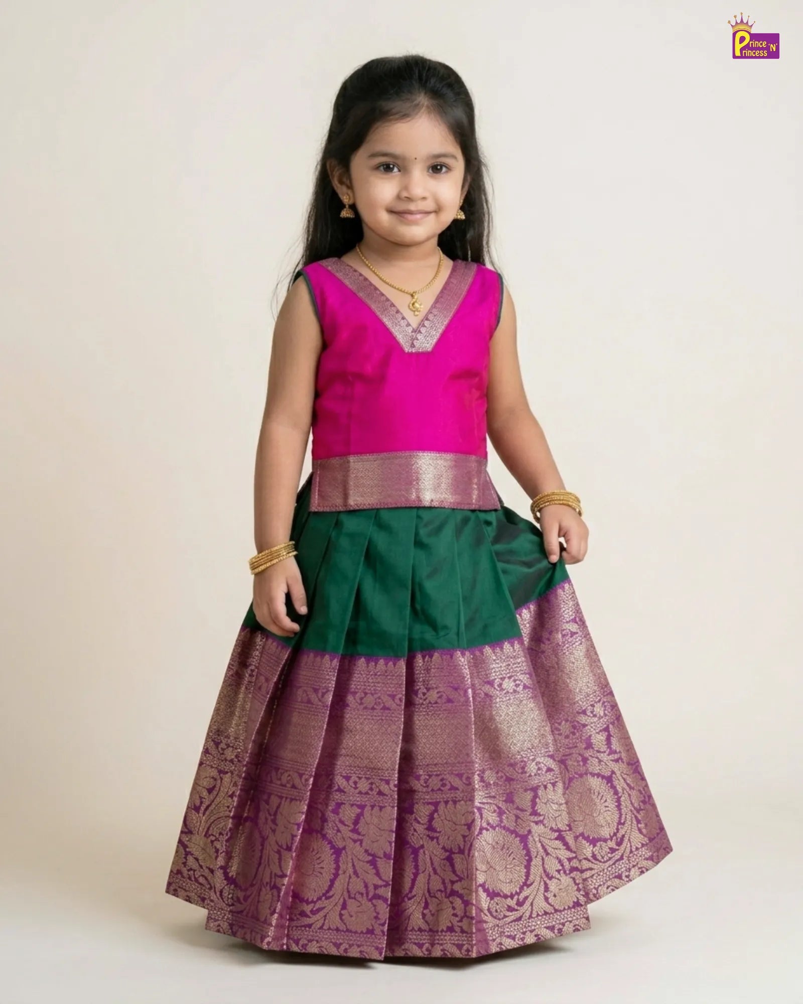 Young girl wearing a traditional outfit with a pink blouse and green and purple skirt on a white background