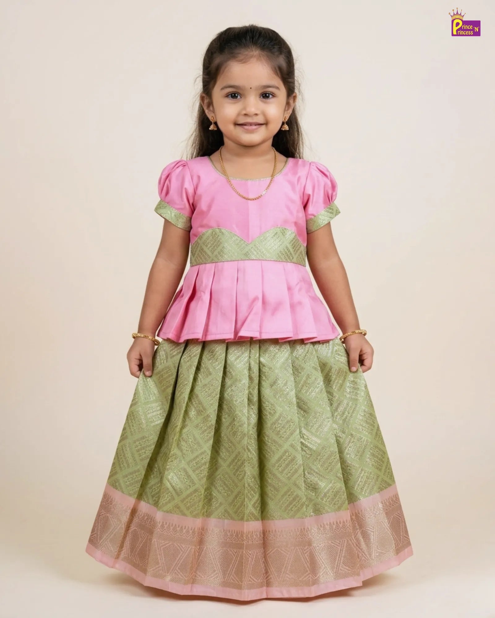 Young girl wearing a pink top and green skirt with a beige background