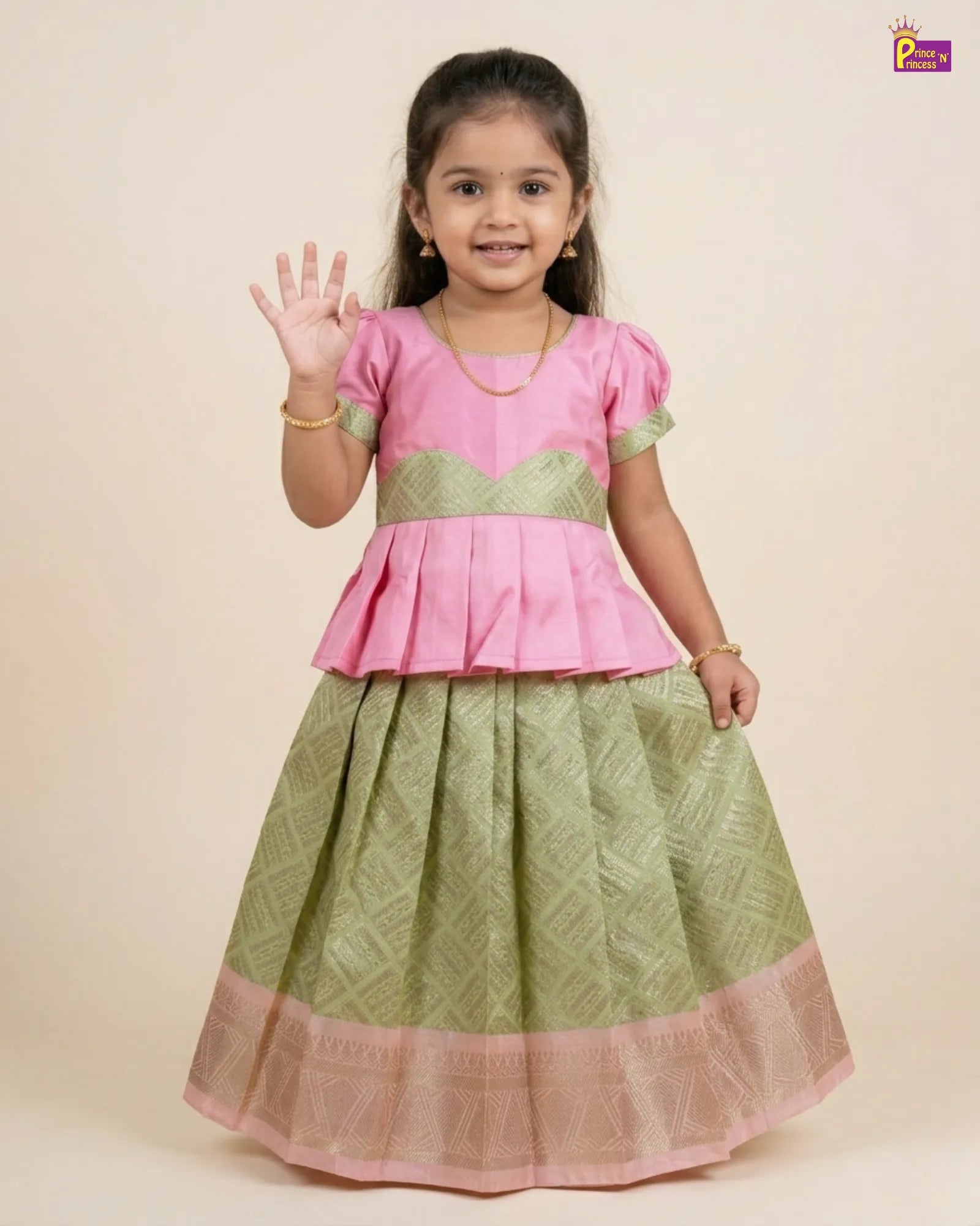 Young girl wearing a pink and green traditional outfit on a beige background