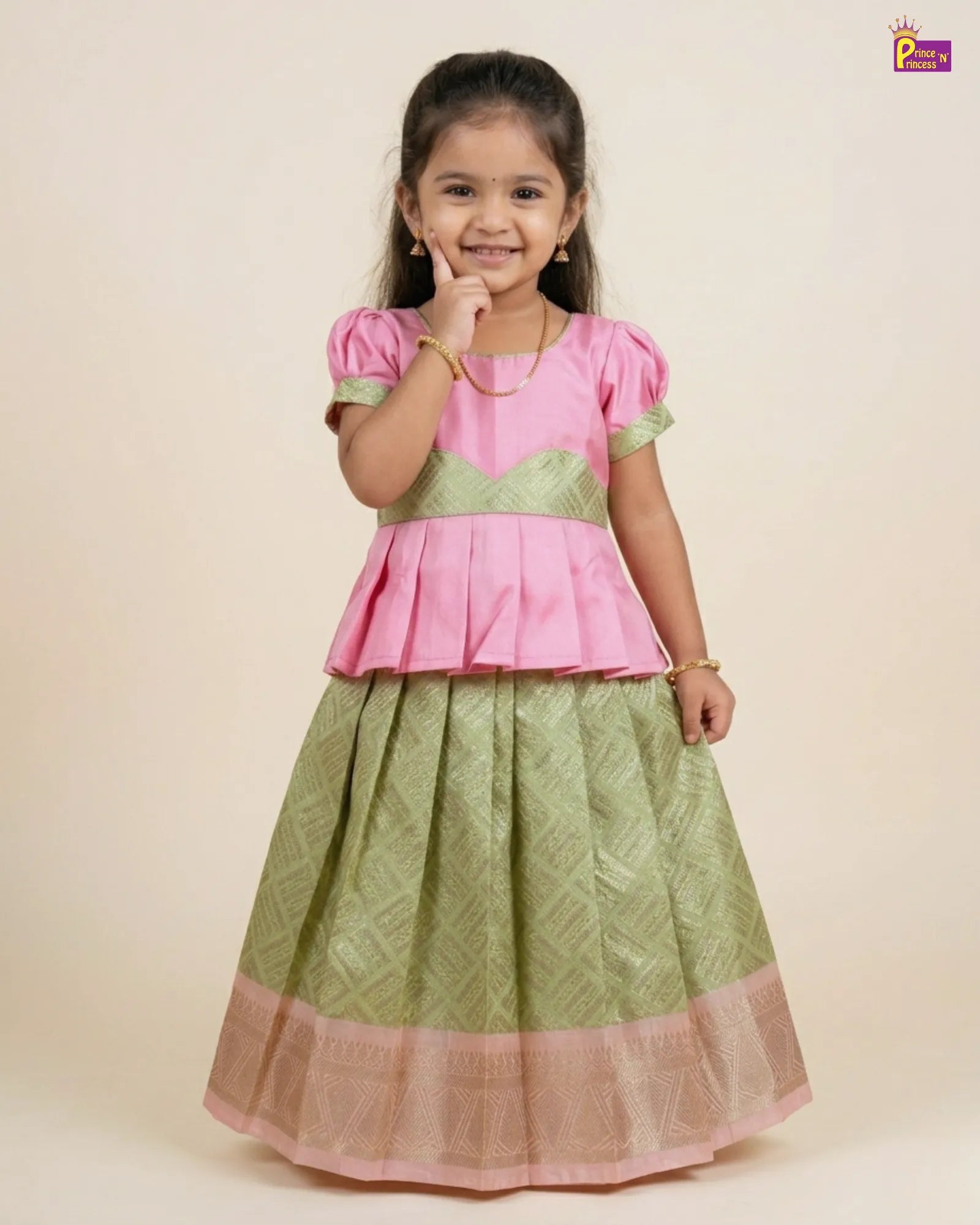 Young girl wearing a pink top and green skirt with a subtle pattern on a beige background