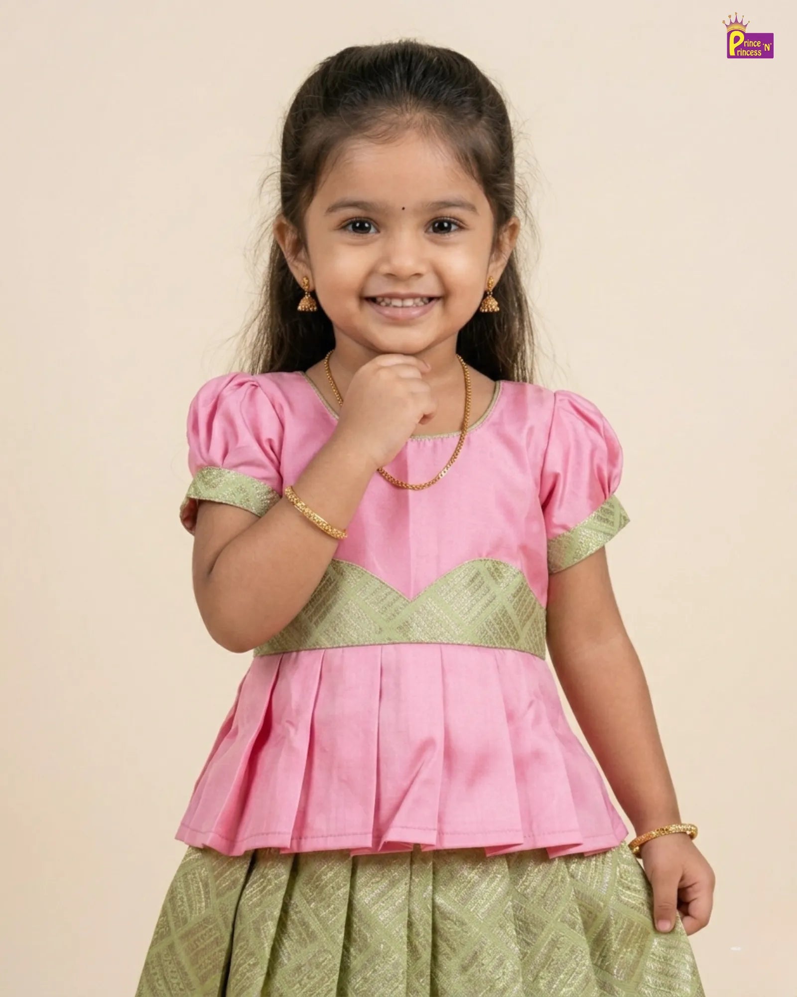 Young girl wearing a pink and green traditional outfit on a beige background