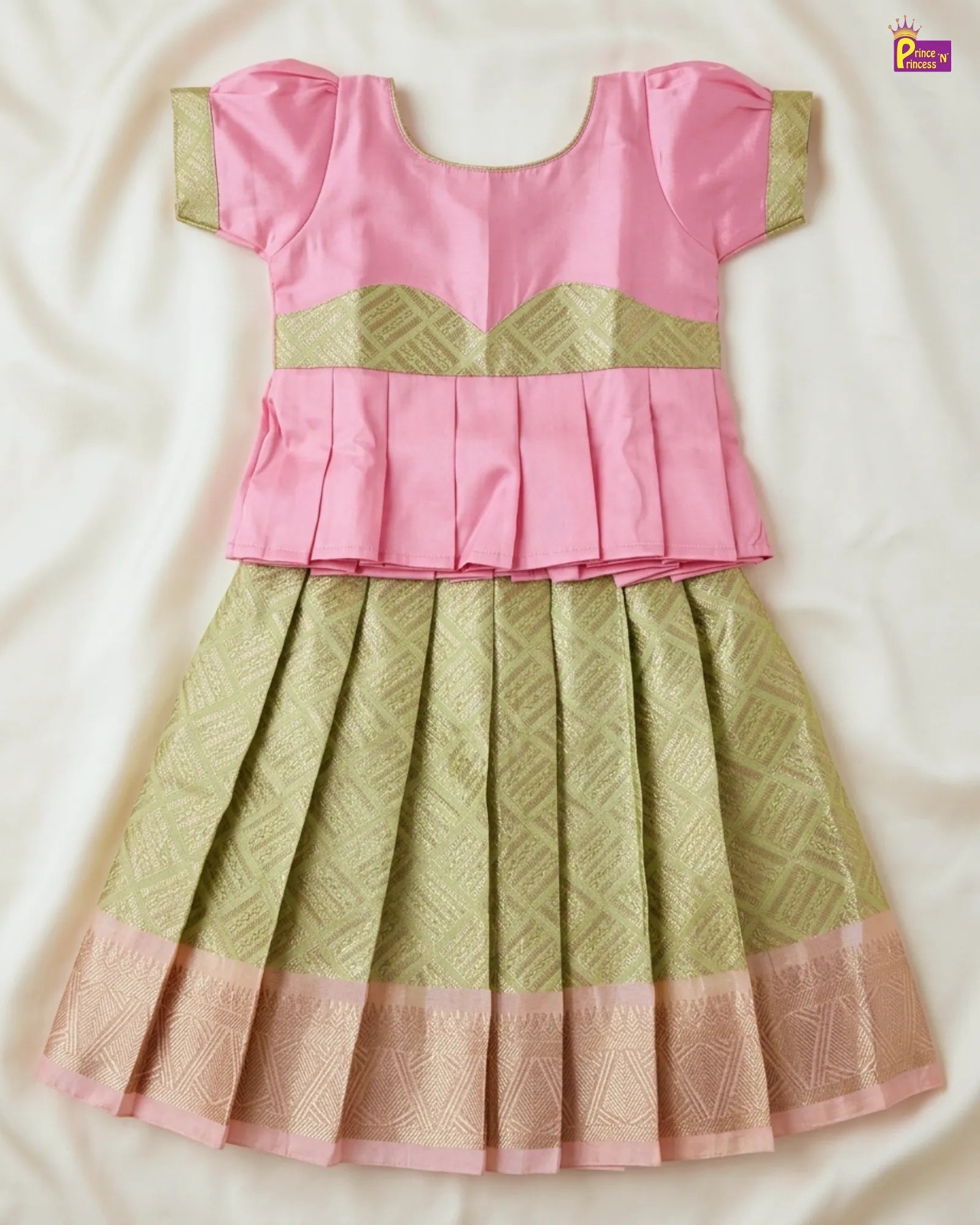 Pink and green traditional outfit with intricate patterns on a white background