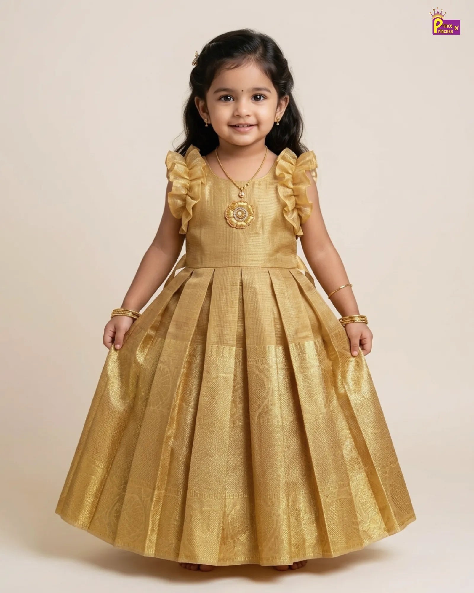 Young girl wearing a gold dress with ruffled sleeves on a beige background