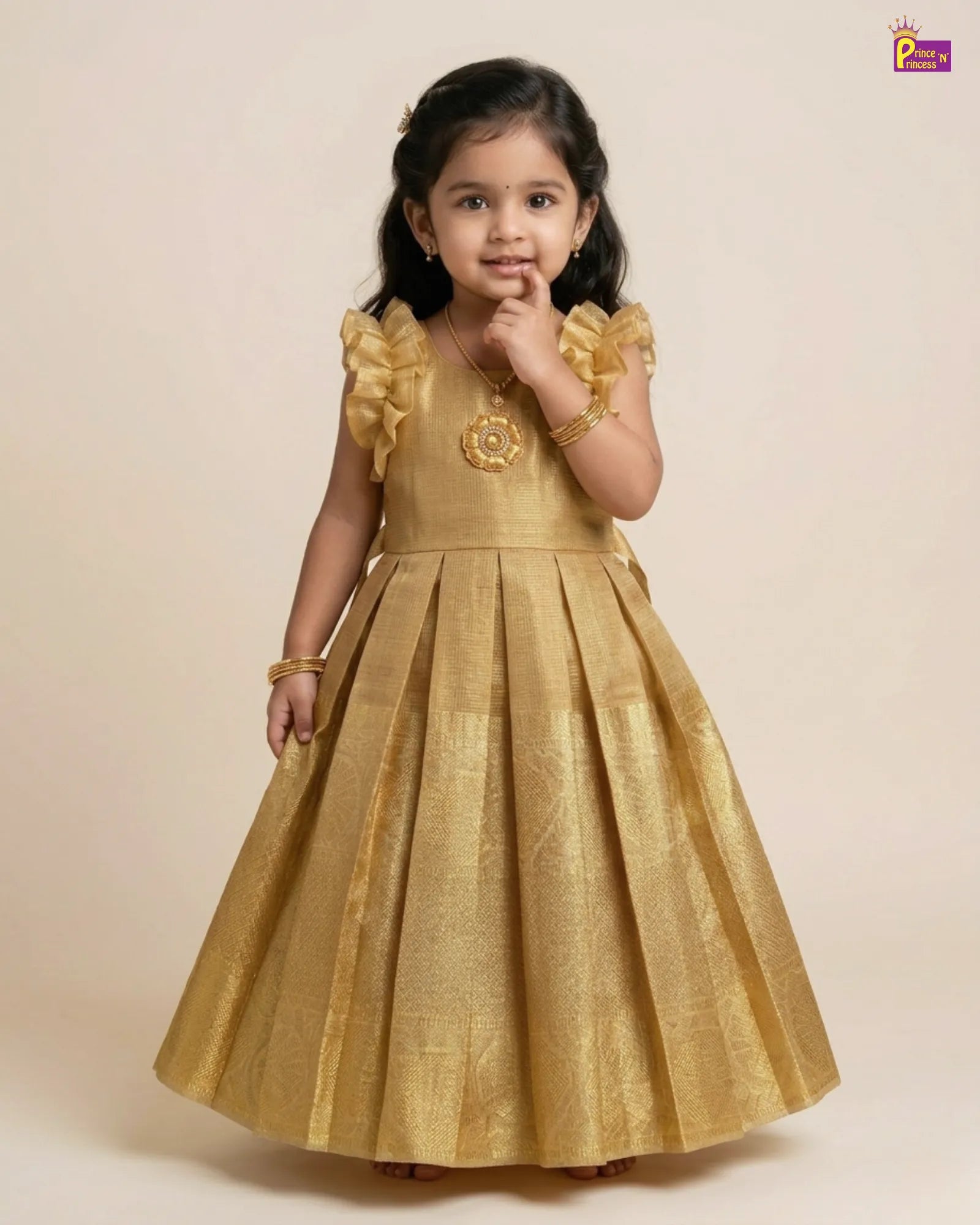 Young girl wearing a gold dress with floral details on a beige background