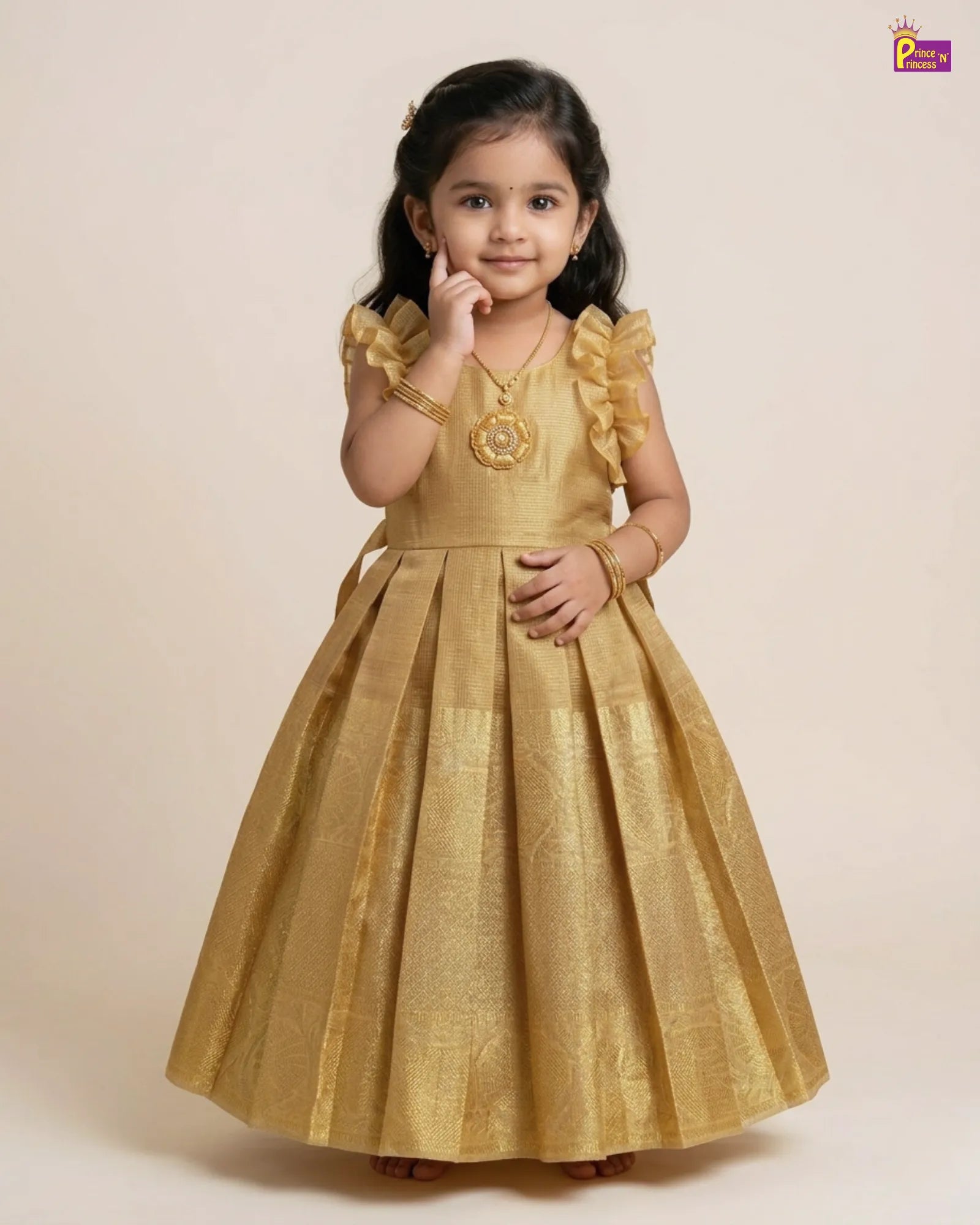 Young girl wearing a gold dress with ruffled sleeves on a beige background