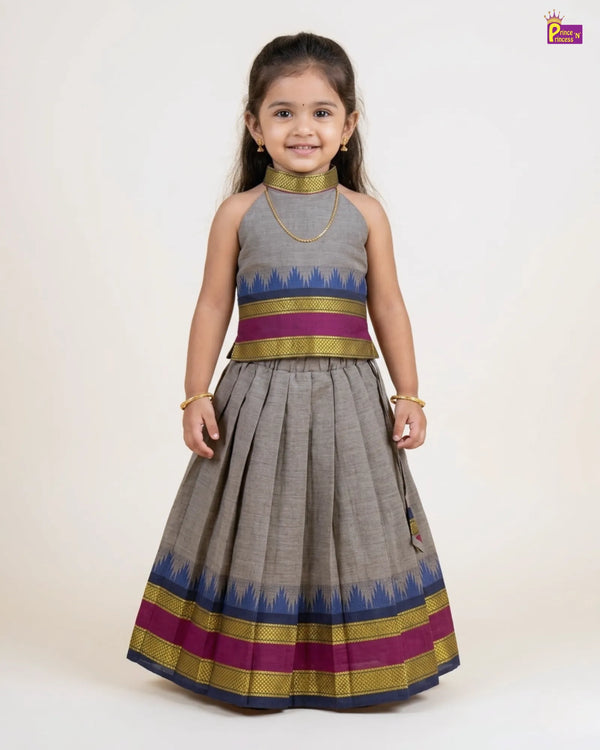 Young girl wearing a traditional outfit with a gray dress and colorful stripes on a white background