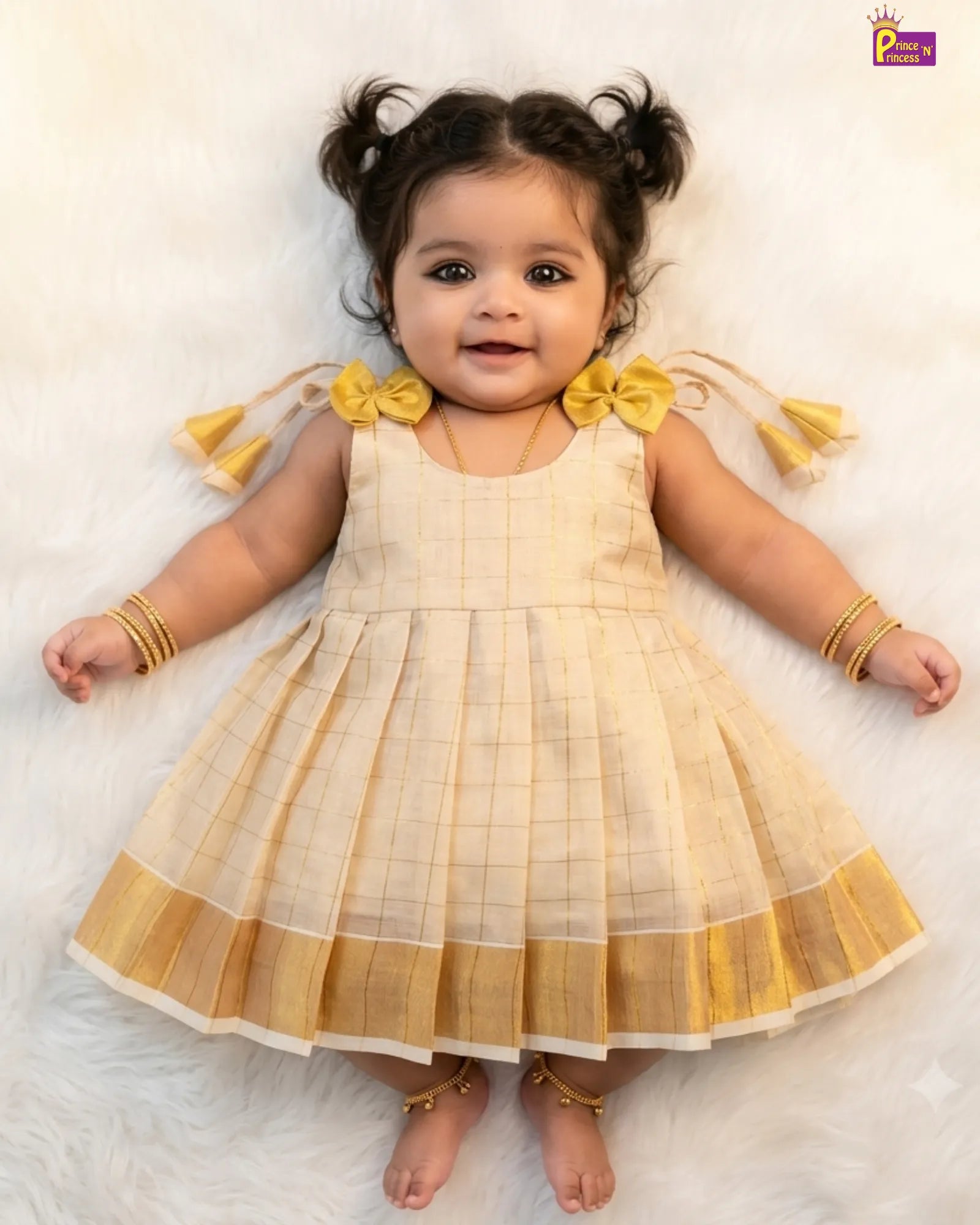 Baby wearing a yellow and white checkered dress with bow details on a light background