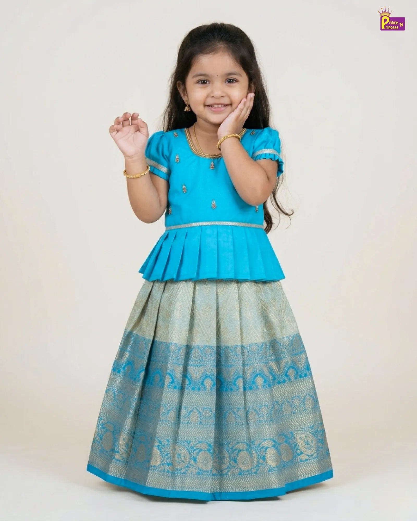 Young girl wearing a blue top and patterned skirt on a white background