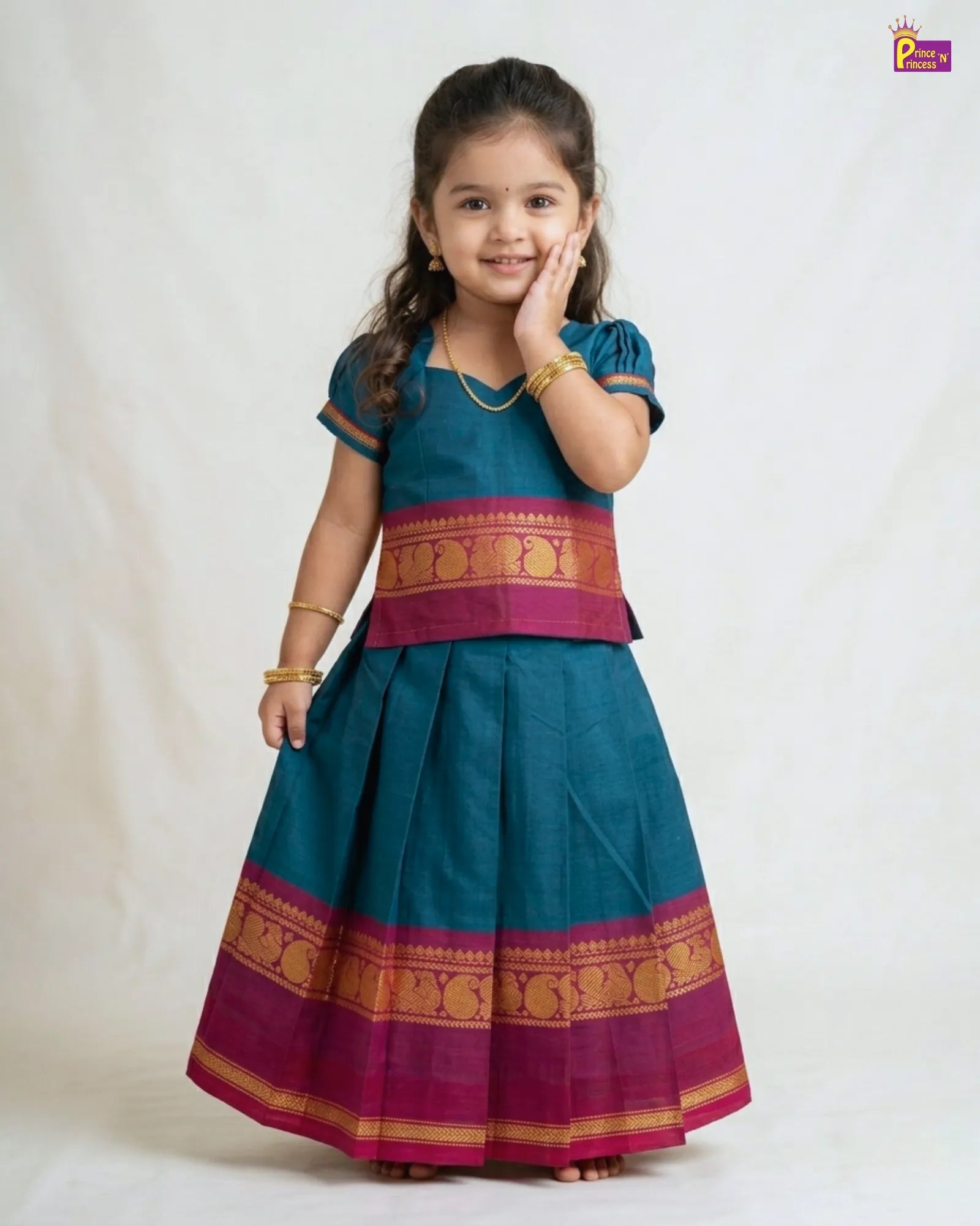 Young girl wearing a traditional outfit with a blue and pink color scheme on a white background