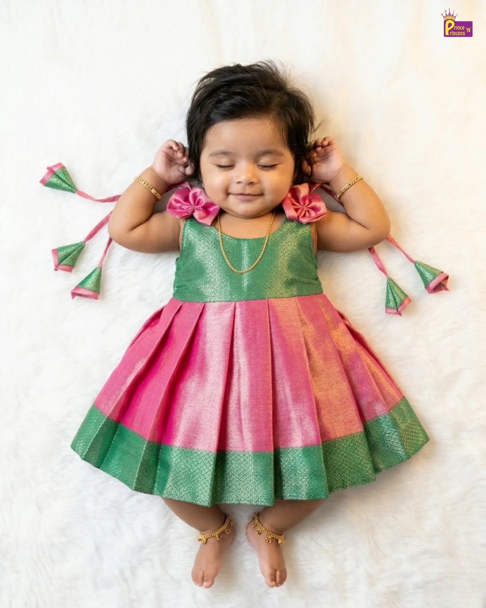 Child wearing a green and pink dress with decorative accessories on a white background