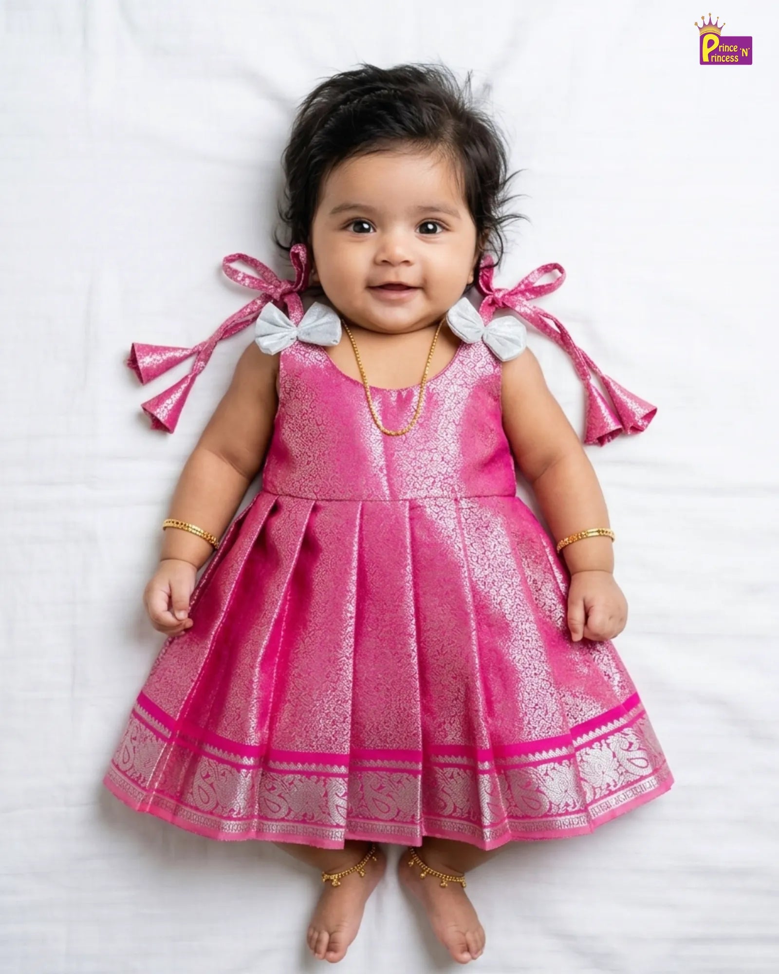 Child wearing a traditional dress with floral embellishments on a plain background