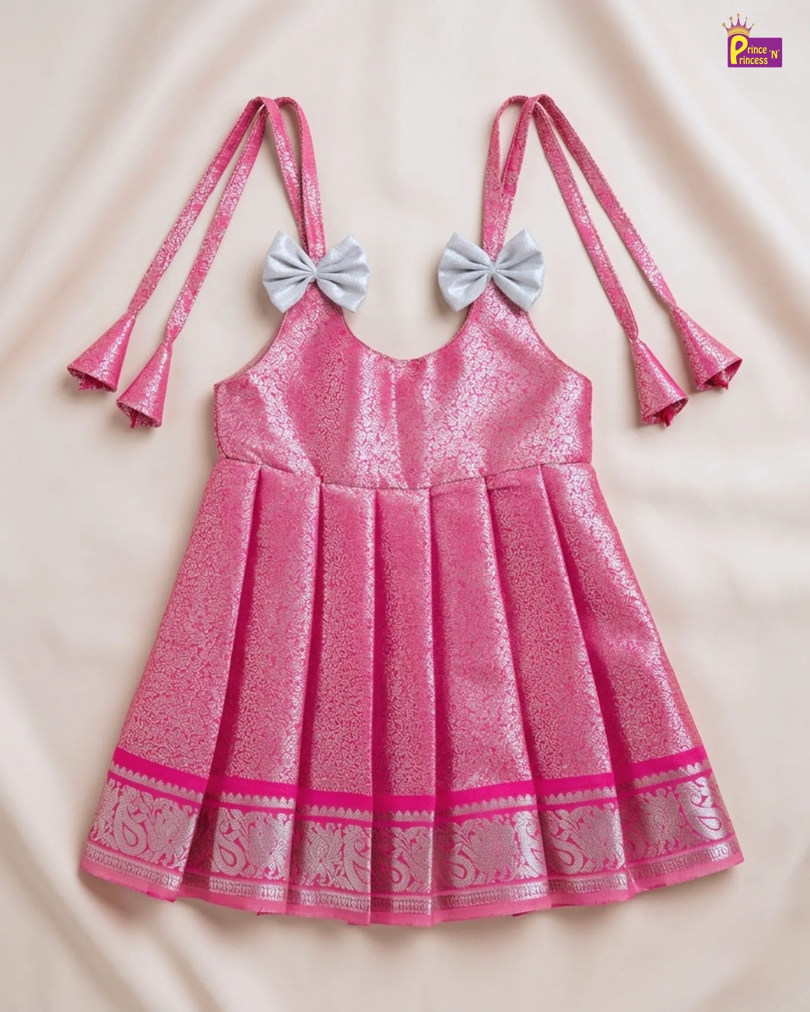 Pink dress with decorative bows on a beige background