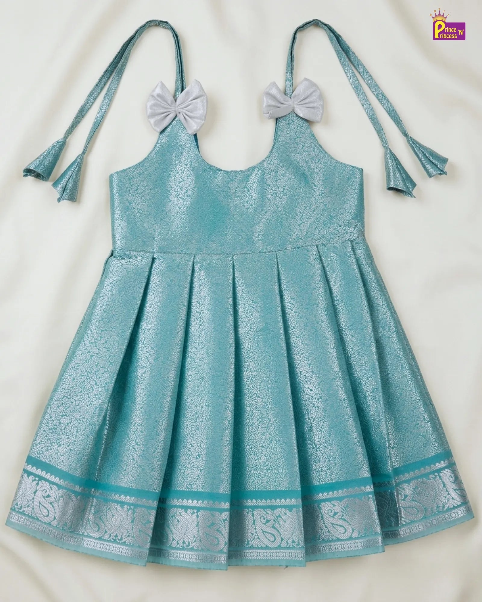 Teal dress with decorative elements on a white background