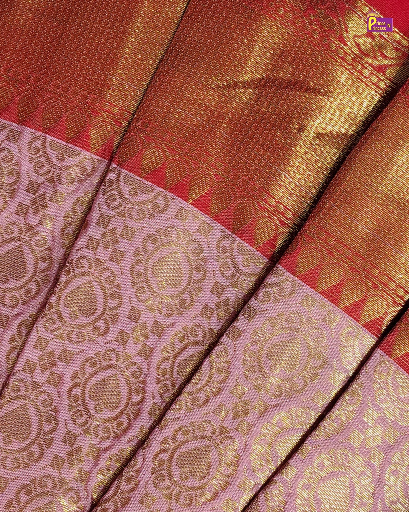 A close-up of a traditional Indian silk saree fabric, showing a pink body with intricate gold zari floral patterns and a wide golden-red border.
