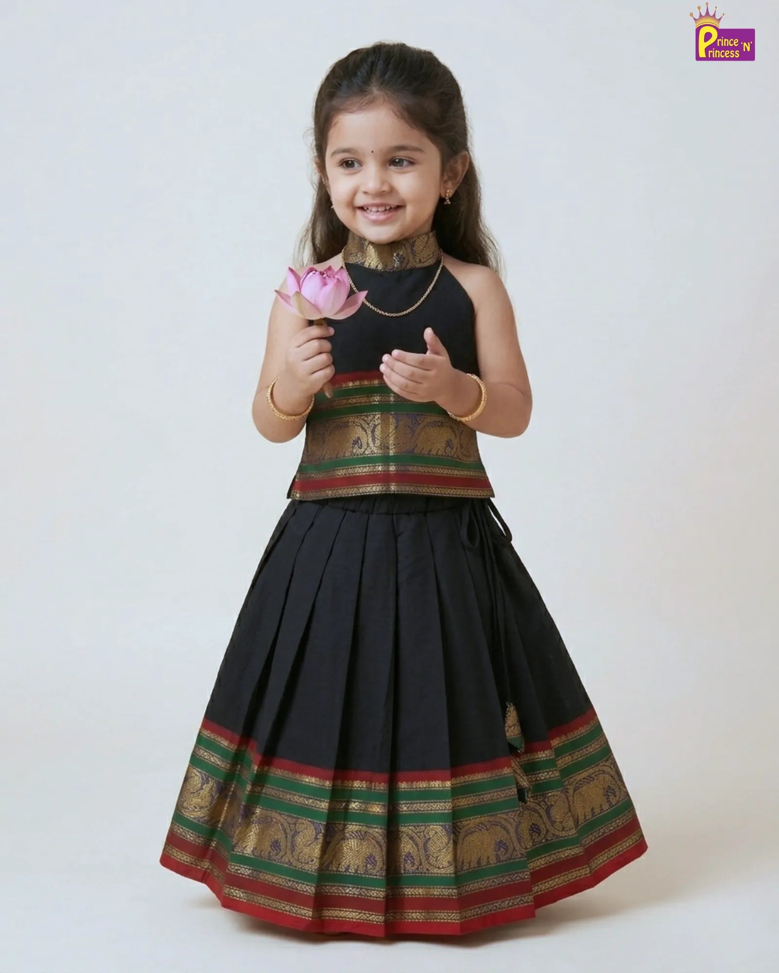 Young girl in a traditional outfit holding a flower against a white background
