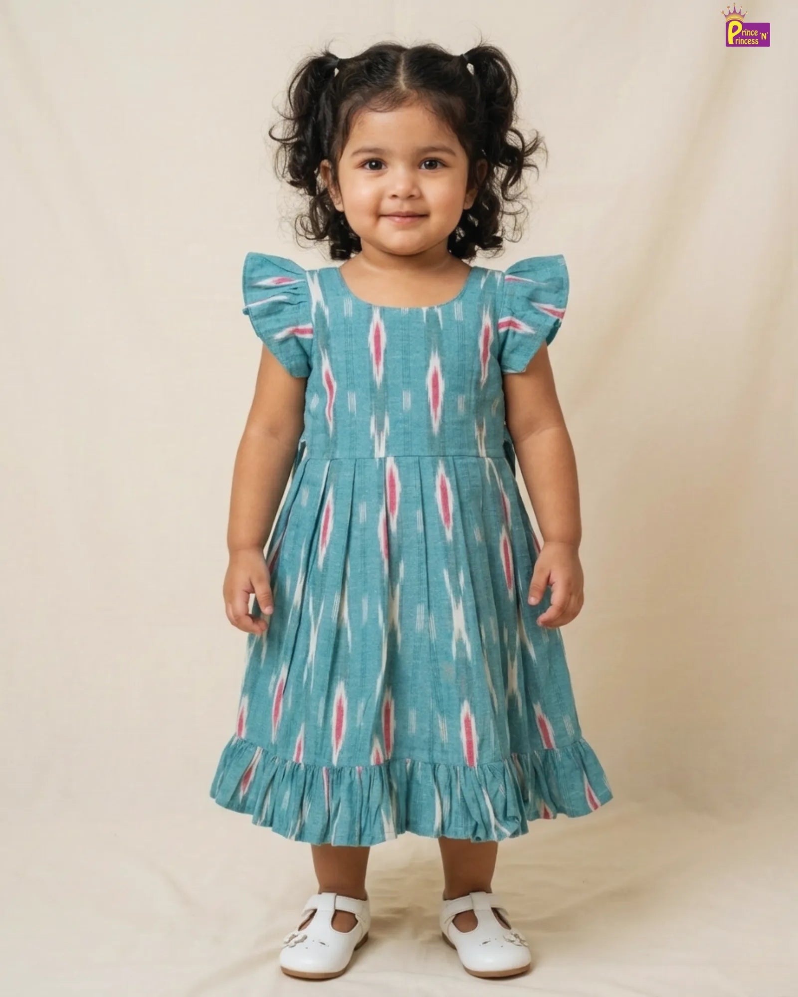 Young girl wearing a blue dress with pink patterns on a beige background