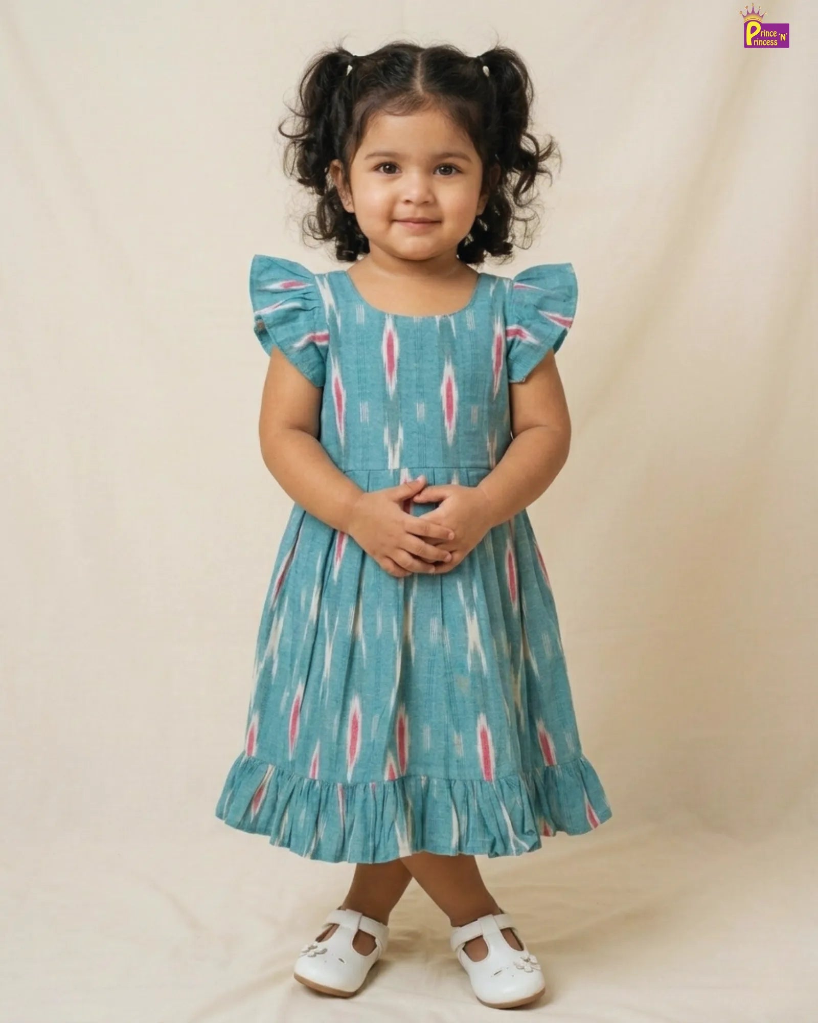 Young girl wearing a blue dress with a pattern on a beige background