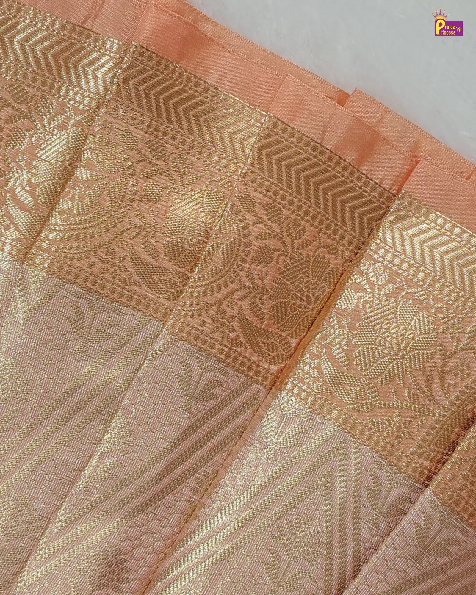 Close-up of a pink fabric with gold intricate patterns