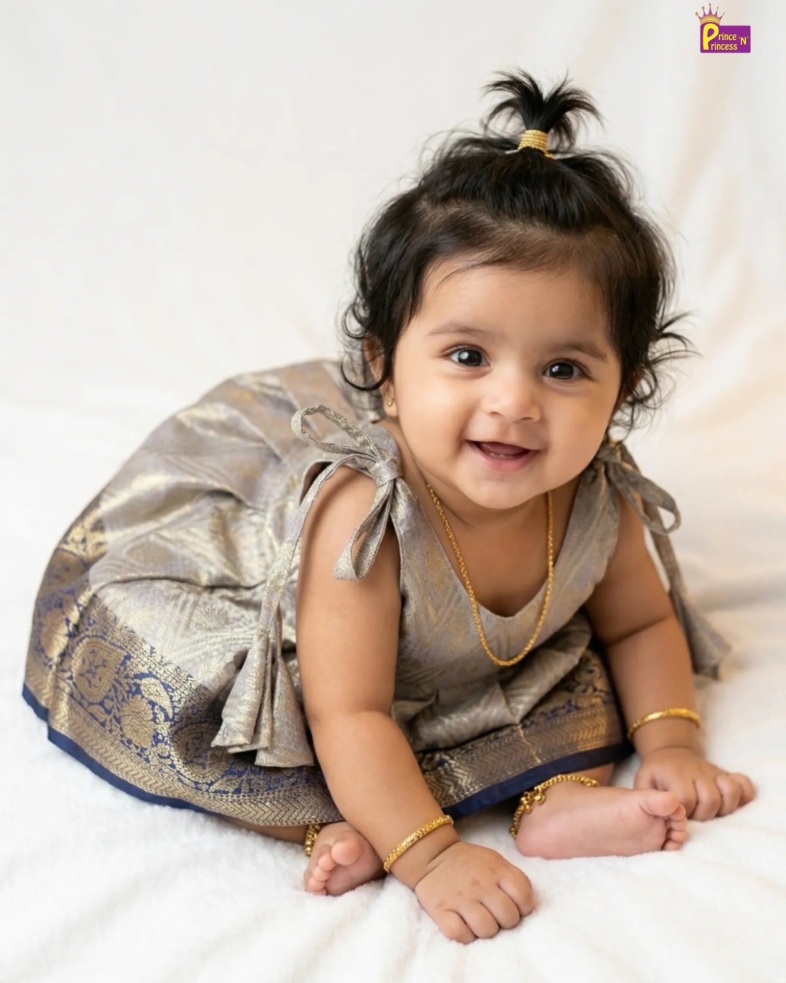 Close-up of wide navy blue Kanjivaram gold paisley zari border and chevron detail on Prince N Princess silver grey Banarasi baby girl frock
