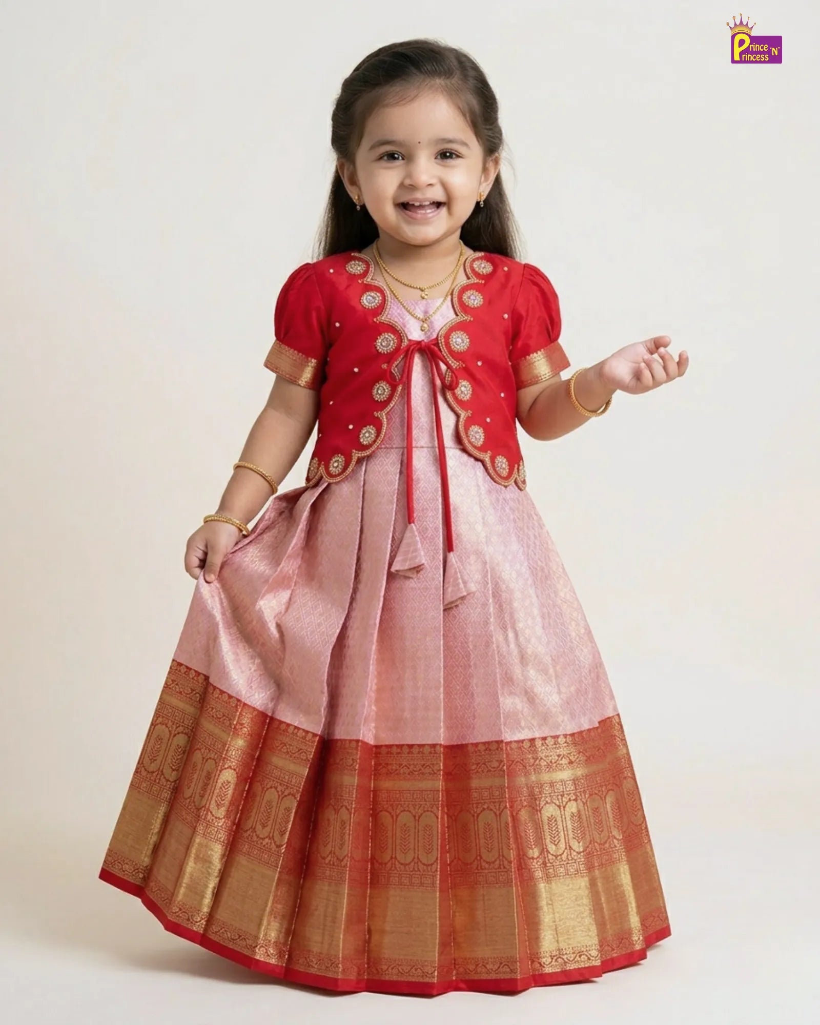 Young girl wearing a traditional outfit with a red and pink dress on a white background
