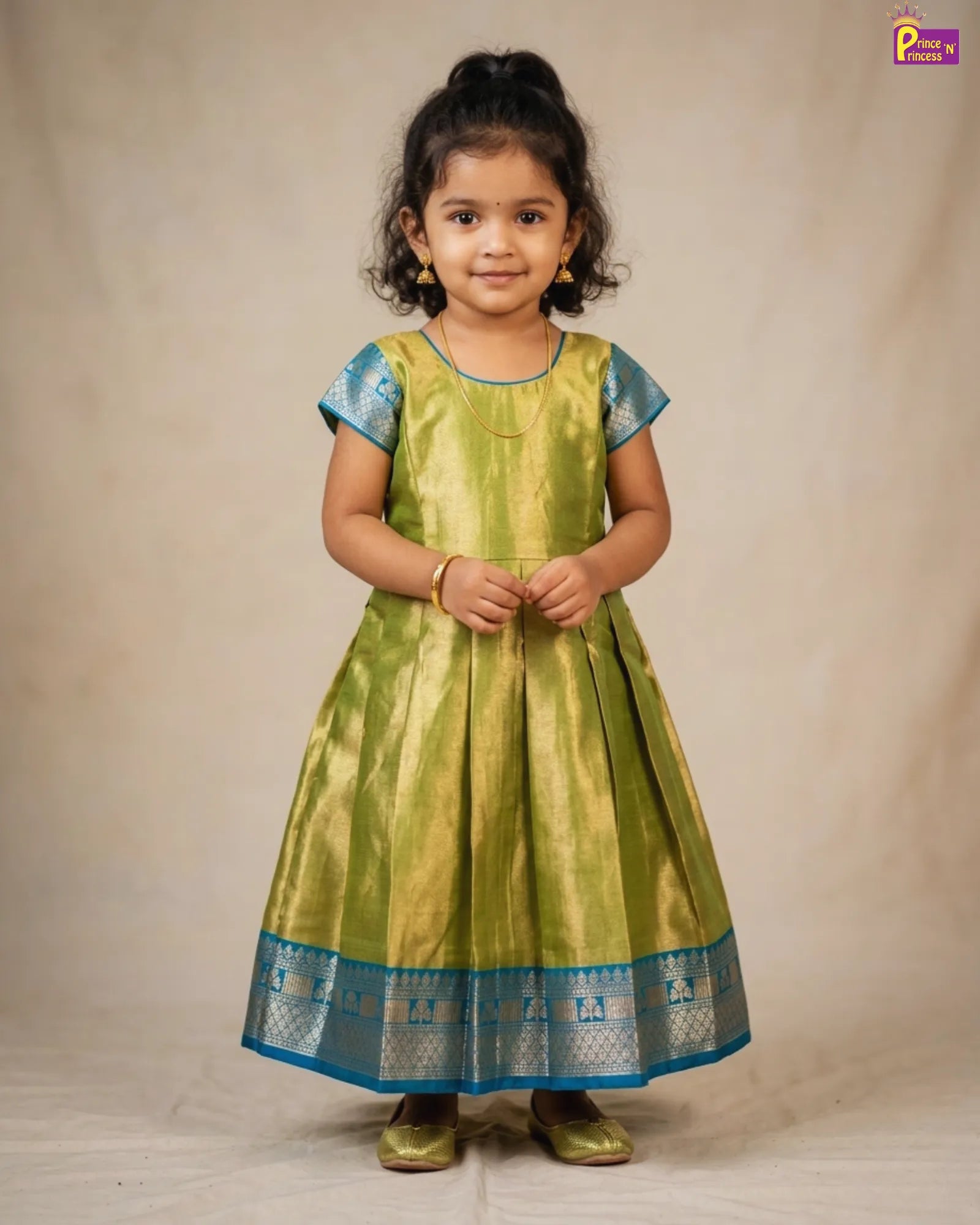 Young girl wearing a green and blue traditional outfit on a beige background