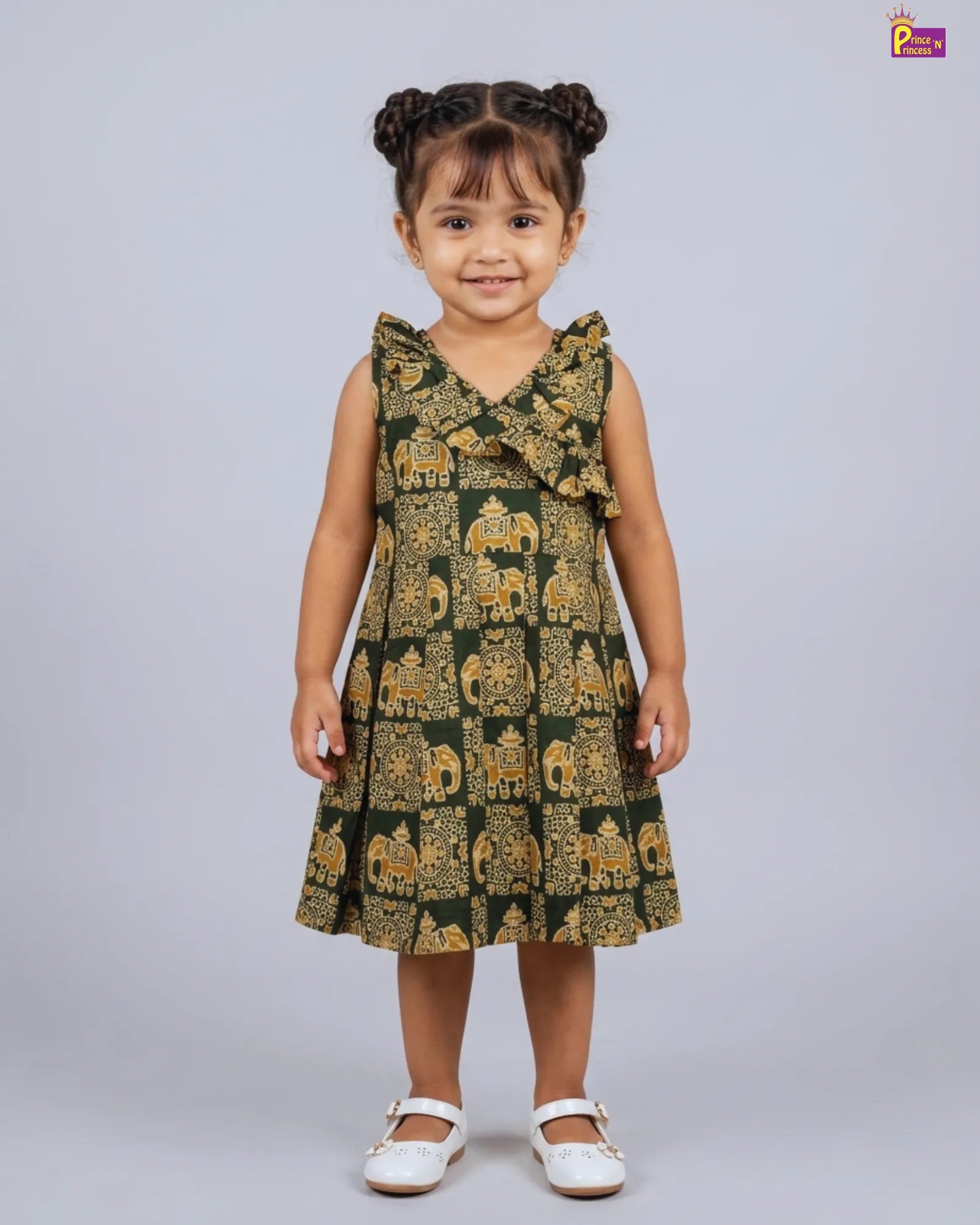 Young girl wearing a green dress with elephant pattern on a white background