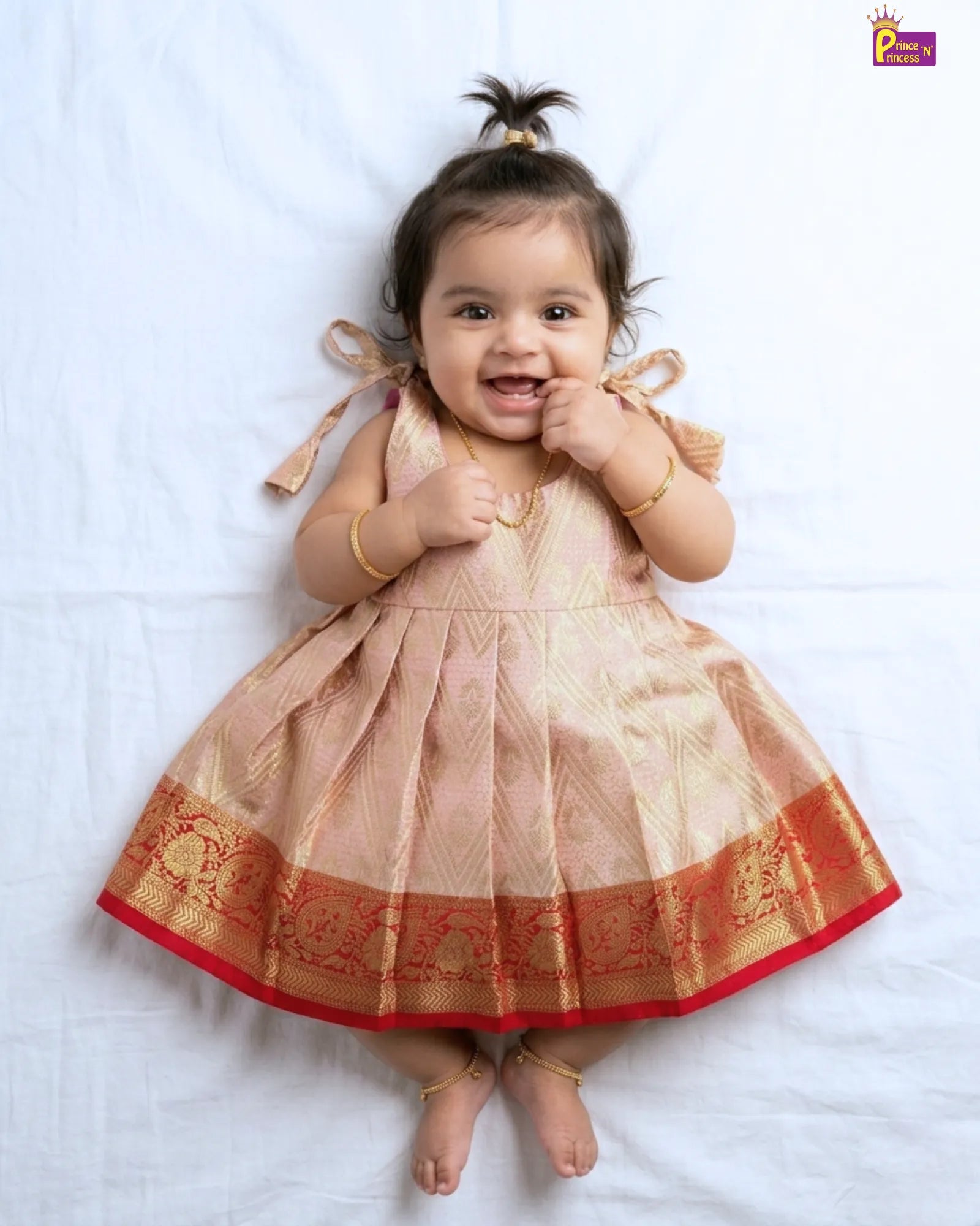 Baby wearing a traditional dress with intricate patterns on a white background only at princenprincess