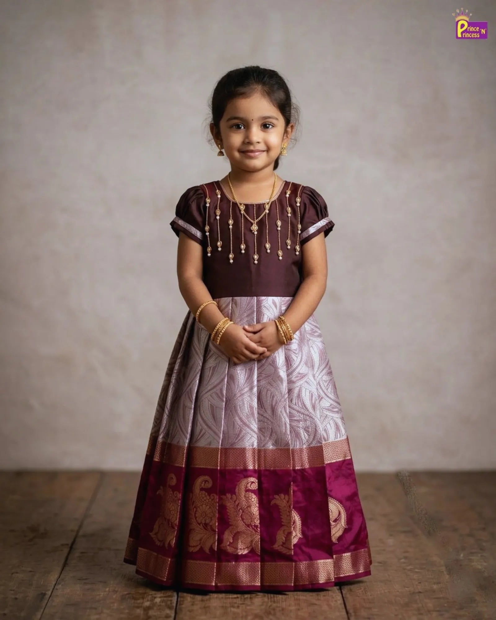 Girl wearing traditional pattu gown with Aari work brown festive kids dress