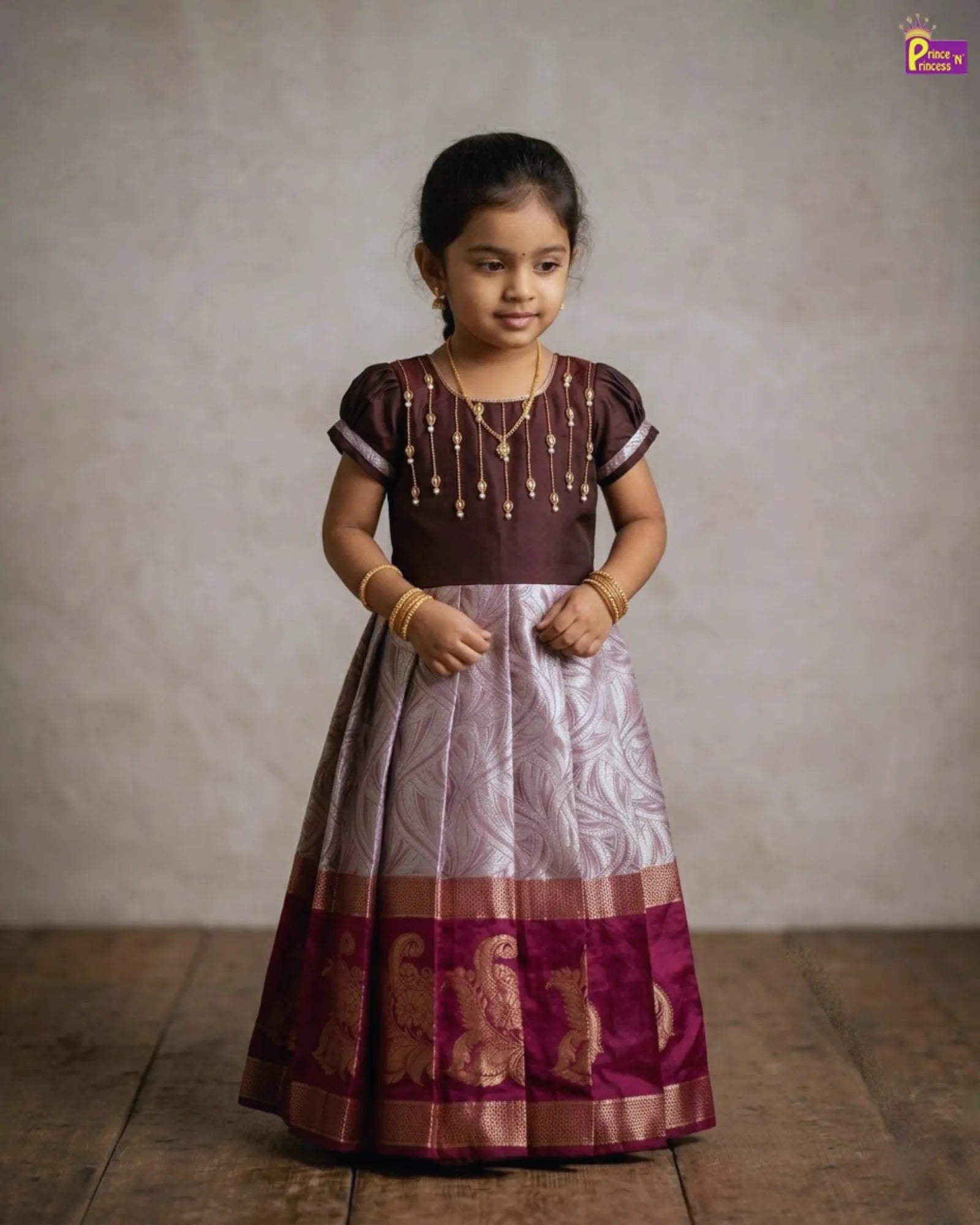 Girl wearing traditional pattu gown with Aari work brown festive kids dress