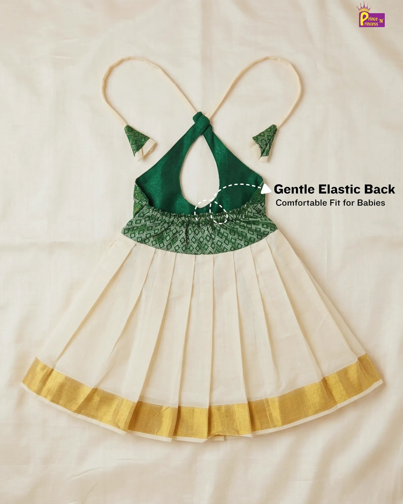 Green and gold baby dress with a gentle elastic back on a beige background