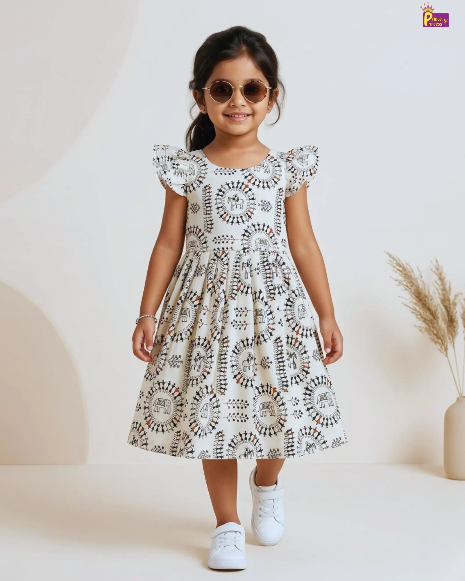 Young girl wearing a blue dress with floral patterns on a plain background