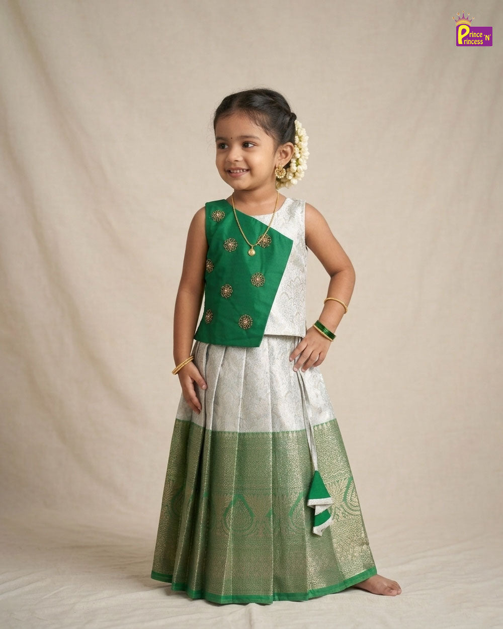 Young girl wearing a green and white traditional outfit on a beige background - Prince N Princess